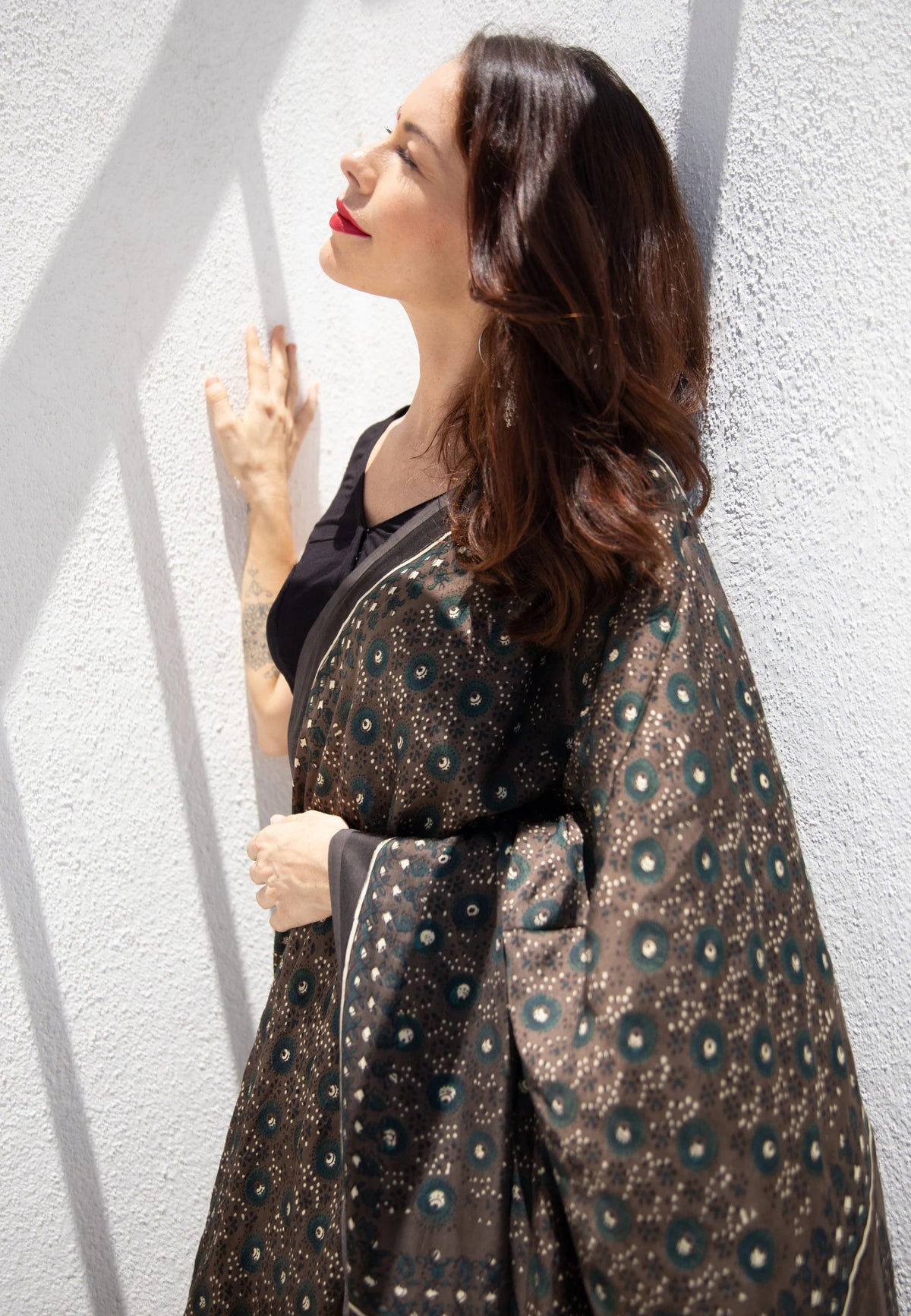 Grey Ajrakh hand block printed modal silk saree, naturally dyed and handcrafted by artisans in Gujarat, India. Features soft luxurious drape, intricate prints, tasselled pallu, and a running blouse inside.