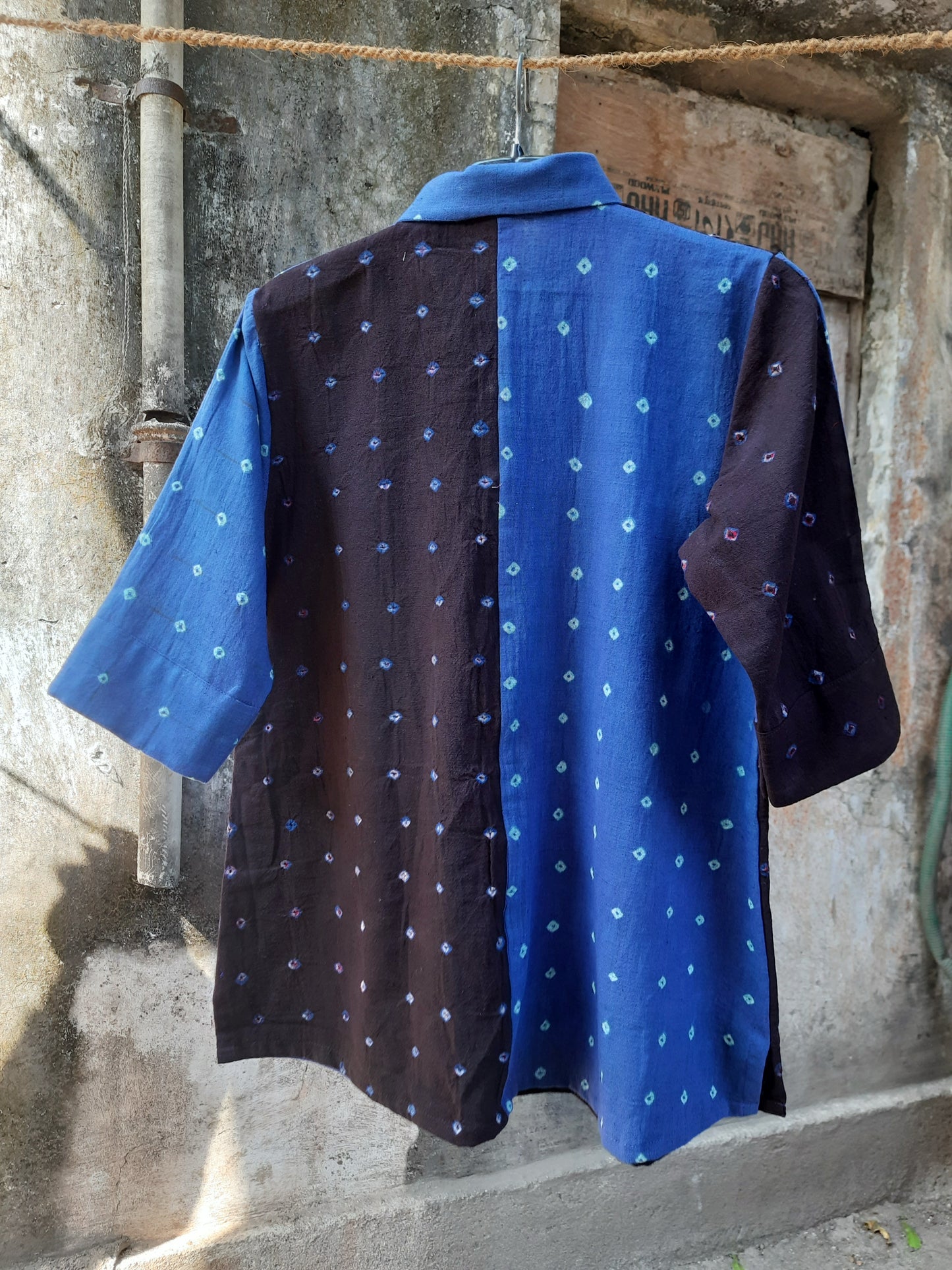 Blue and black half-and-half Bandhani oversized shirt crafted in organic cotton, featuring hand tie dyed patterns on both panels. Relaxed oversized fit, breathable and slow made women’s shirt handcrafted using traditional Bandhani techniques in India.