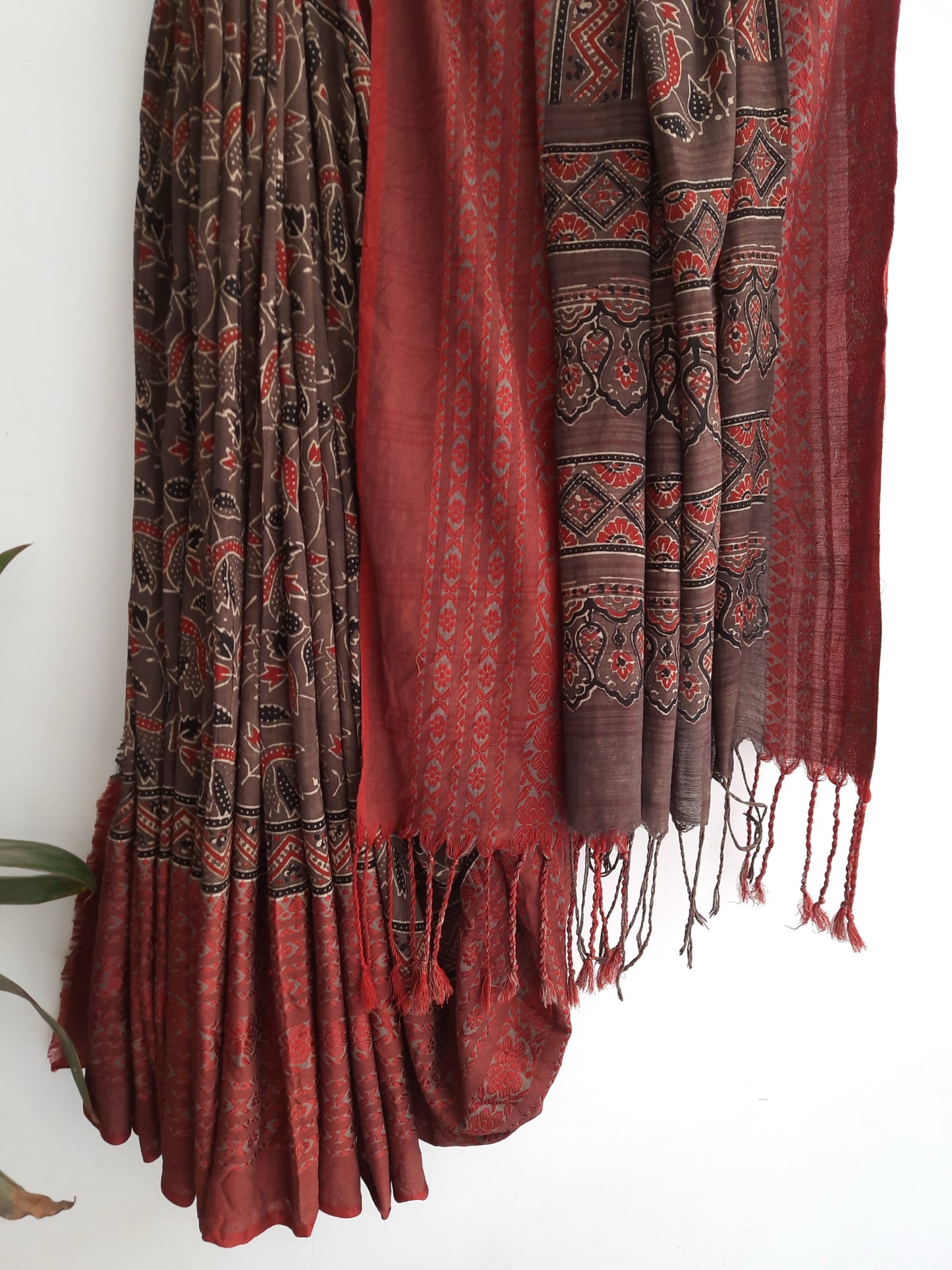 Brown and madder Ajrakh hand block printed cotton saree featuring a brown printed body with madder red borders, self-woven detailing and tassels made from the saree’s own fabric. Natural dyed, breathable, slow made saree handcrafted in Gujarat.