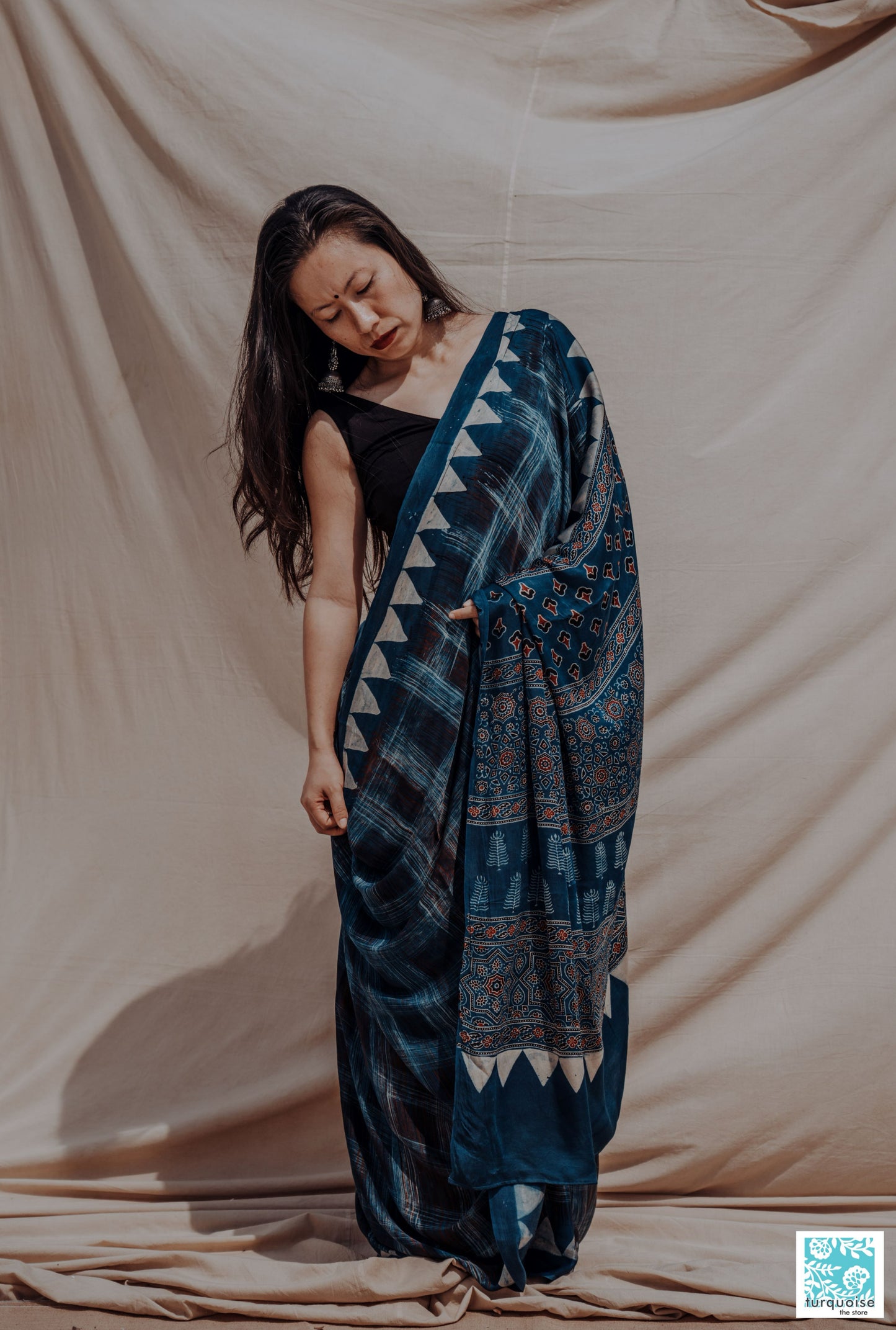 Indigo Ajrakh modal silk saree with natural dye, hand block printed brush-stroke patterns and traditional Ajrakh motifs. Slow-made, handcrafted saree in modal silk, 5.75 meters long, 44-inch width, includes blouse piece.