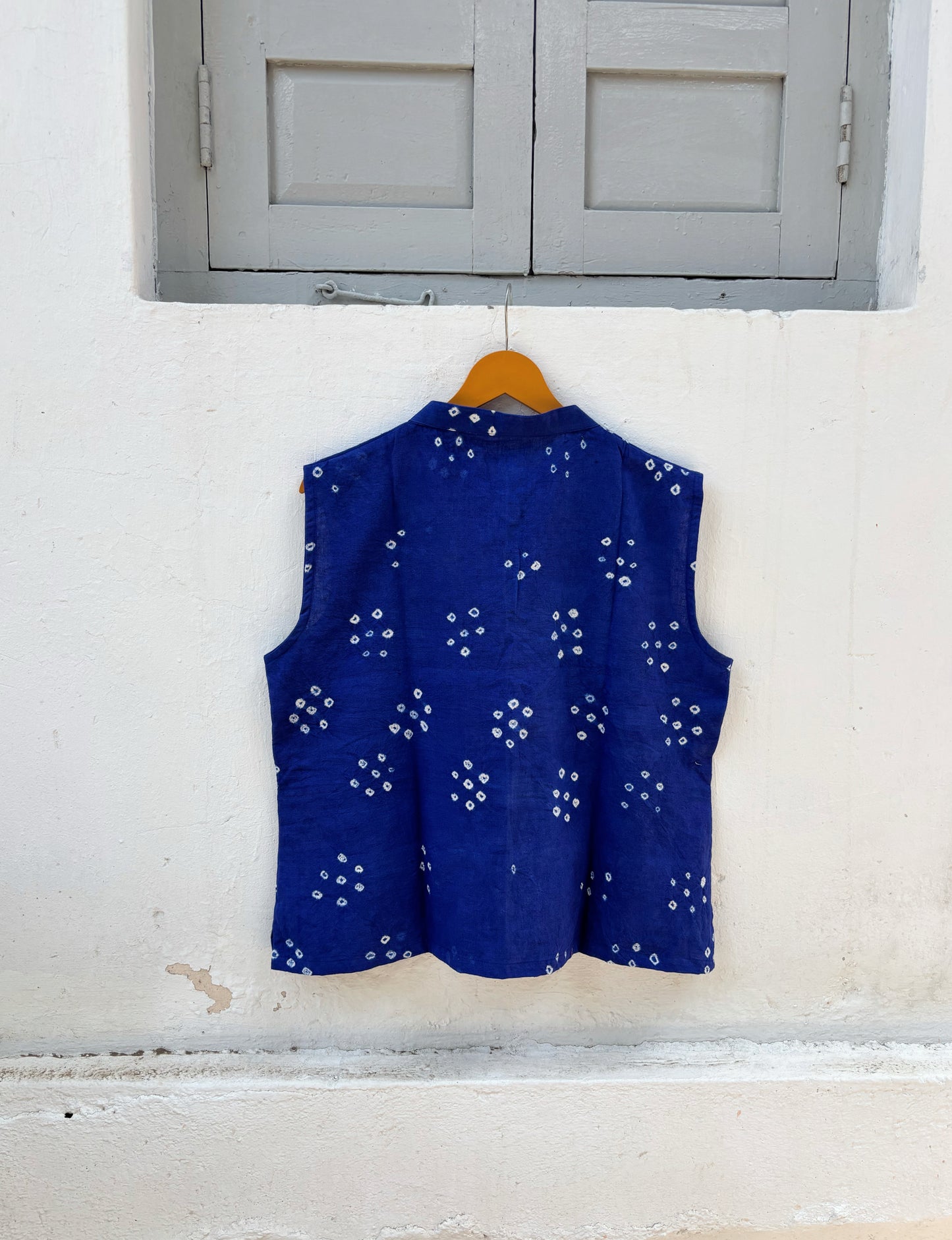 Handspun and handwoven organic cotton sleeveless Bandhani shirt in dusty royal blue with soft mandarin collar, side slits, and relaxed fit.