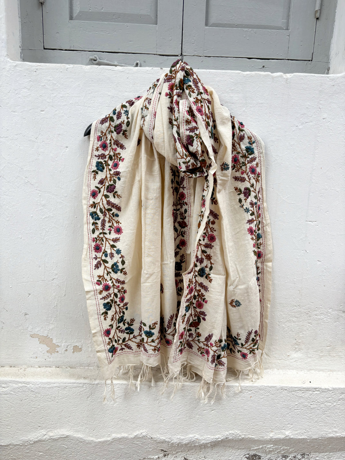 Bela hand spun handwoven off-white cotton dupatta with multicolour floral hand embroidered borders, scattered floral butis, and handcrafted tassels.