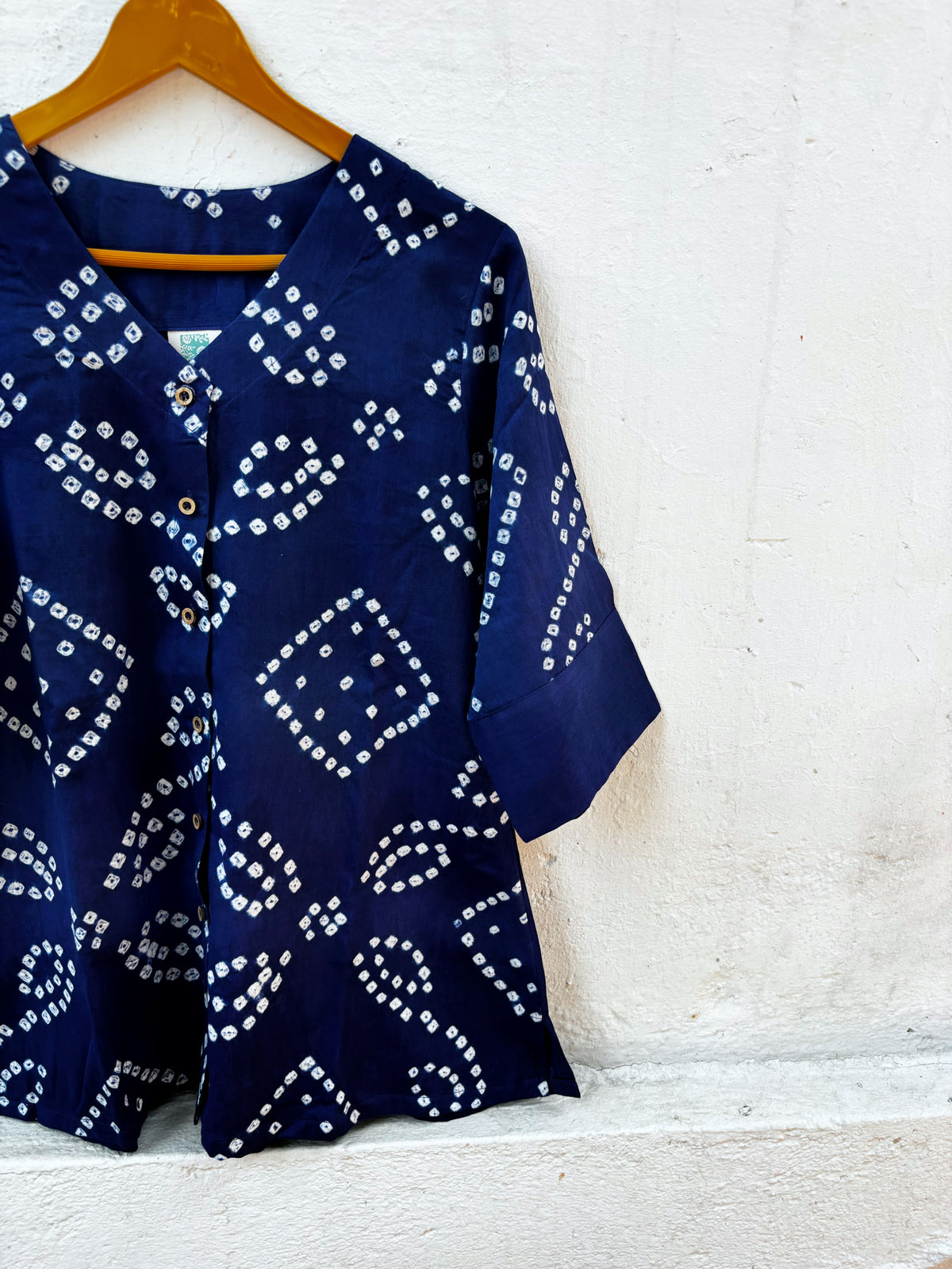 Blue Hour deep ink-blue cotton satin shirt with ivory hand tie-dyed Bandhani motifs, V-neckline and plain sleeve cuffs.