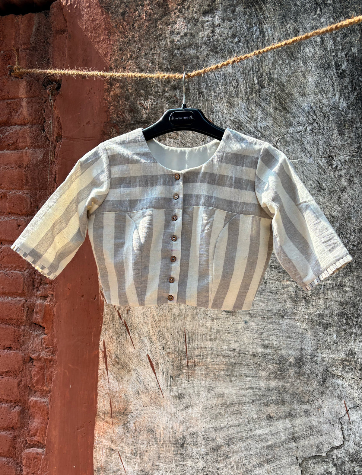 Handspun handwoven organic cotton blouse in ivory and grey stripes with round neck and wooden buttons, slow-made and handmade in India.