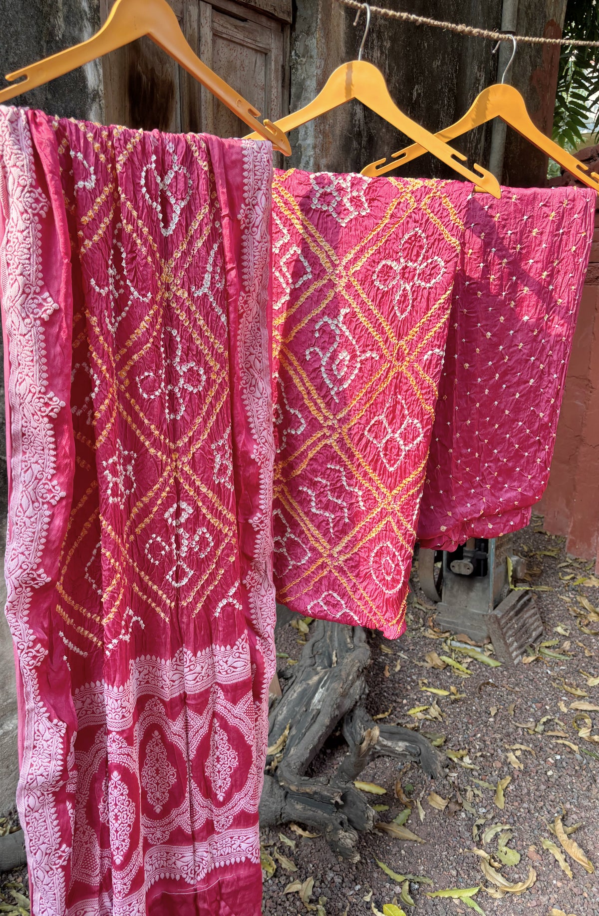 Three-piece muted berry pink modal silk Bandhani unstitched suit set with off-white and mustard-gold motifs.