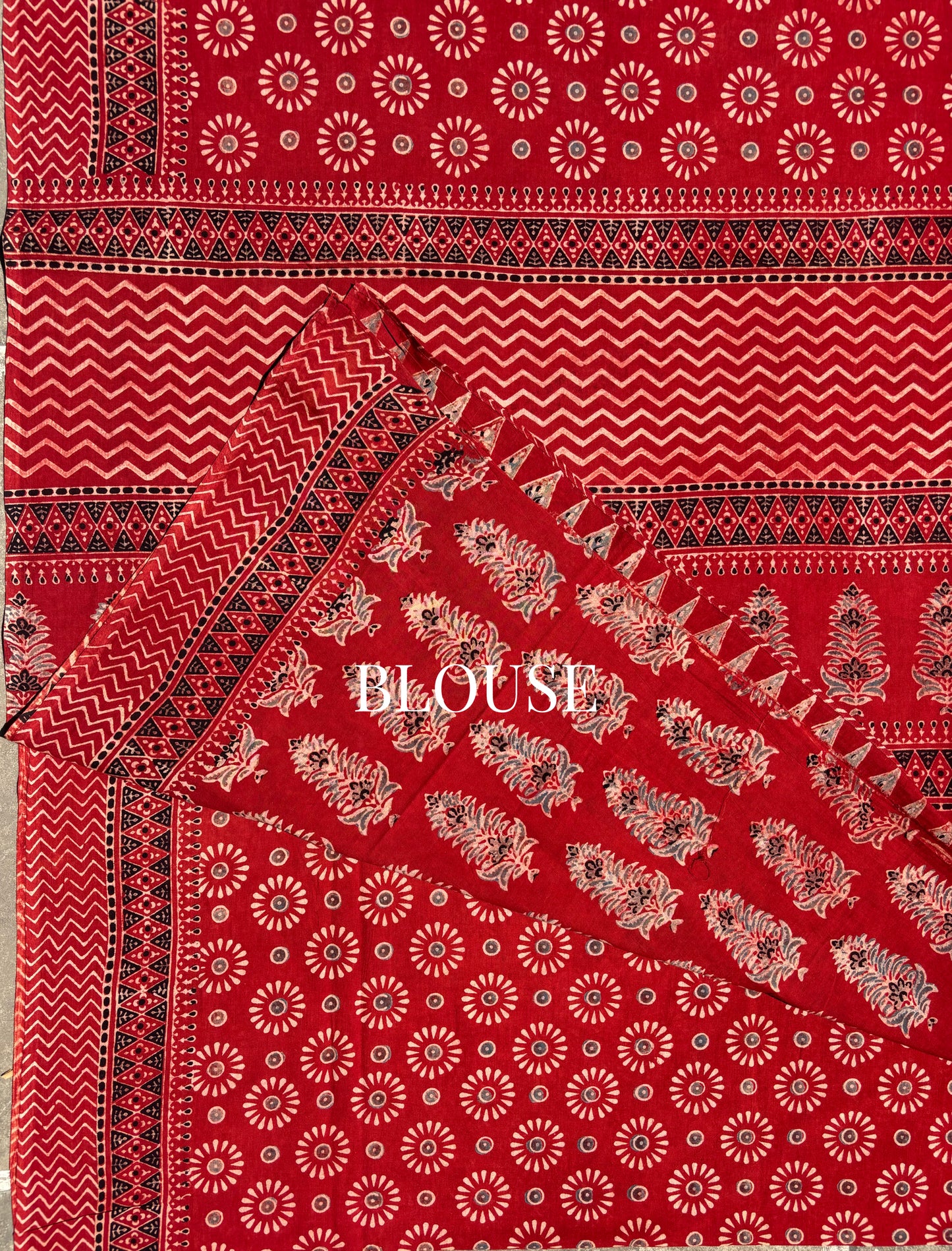 Madder dyed Ajrakh hand block printed cotton saree featuring circular motifs and geometric borders in deep red natural dye.
