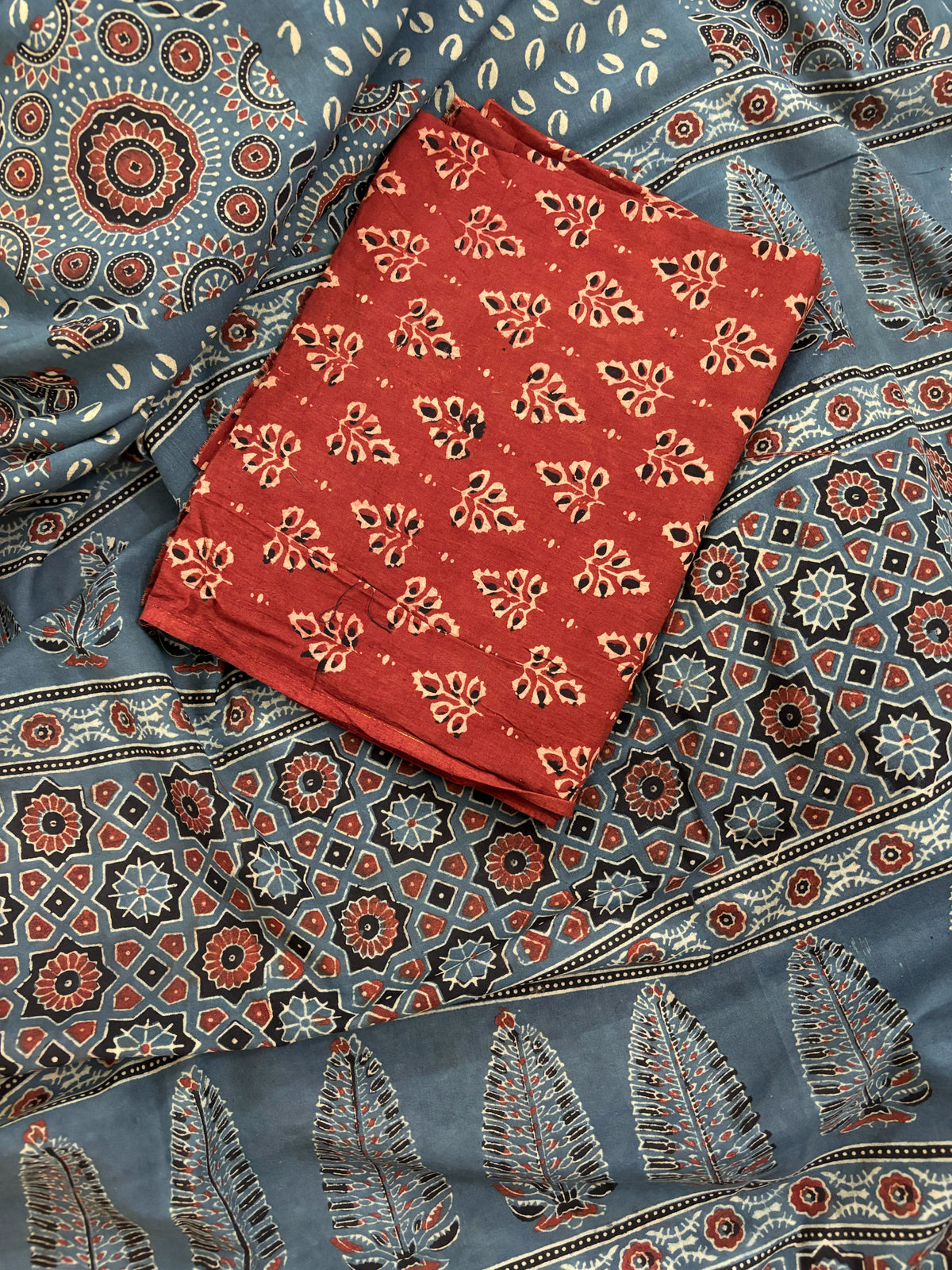 Indigo Ajrakh hand block printed cotton saree featuring traditional circular and geometric motifs with a thin border, paired with a madder dyed Ajrakh blouse piece.