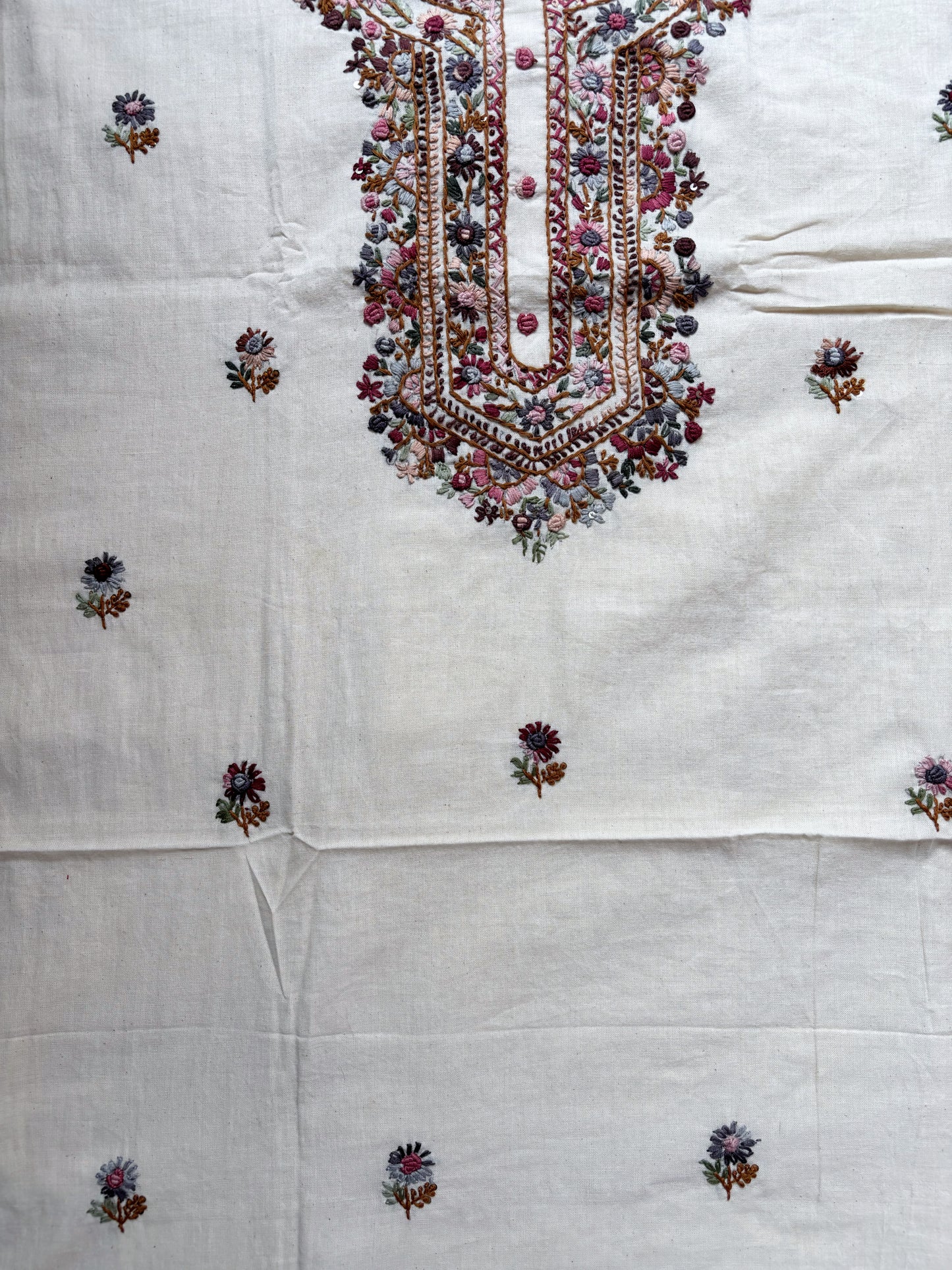 Handspun cotton unstitched kurta dupatta set with a finely hand embroidered floral yoke, small butti motifs on the kurta, and a matching hand embroidered dupatta with tassels in warm ivory tones.