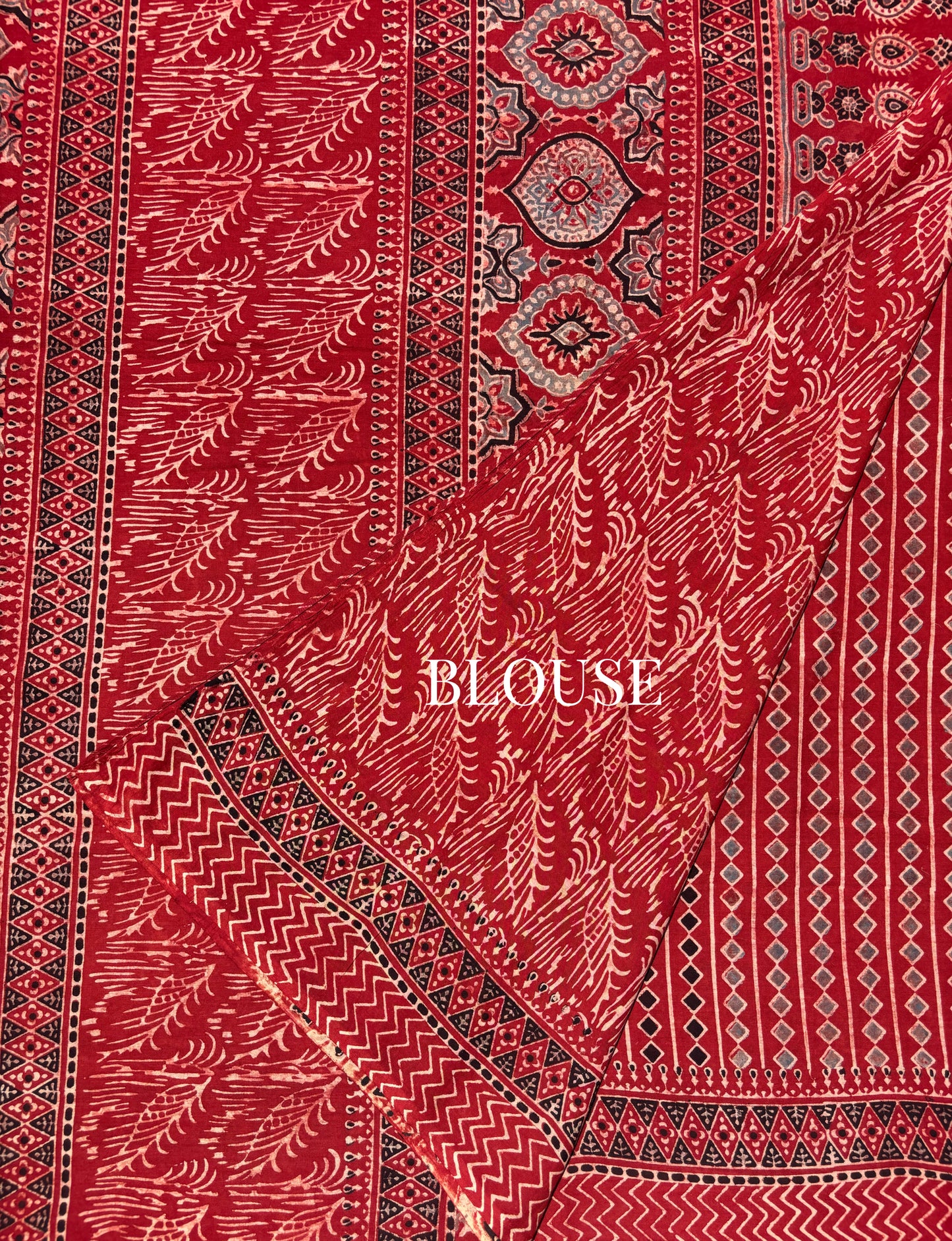 Madder dyed cotton Ajrakh hand block printed saree featuring traditional geometric motifs in red, black, and beige with detailed borders and pallu.