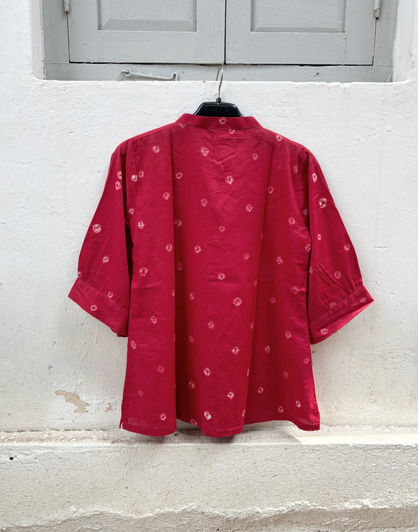 Women's ruby red cotton Bandhani shirt with pleated sleeves and wooden buttons.