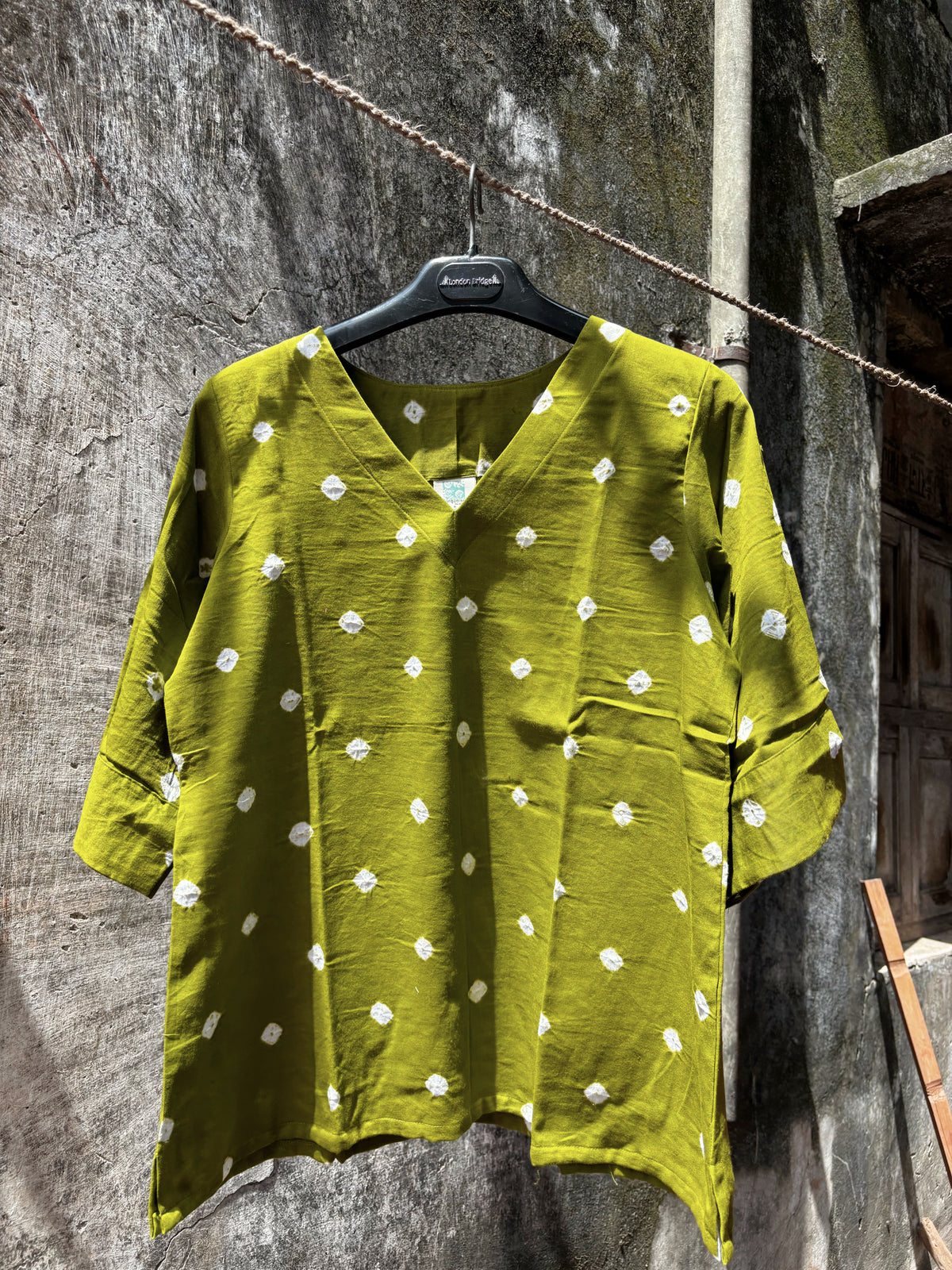 Zaitoon olive green cotton satin top with ivory hand tie-dyed Bandhani motifs, V-neckline and wide three-quarter sleeves.