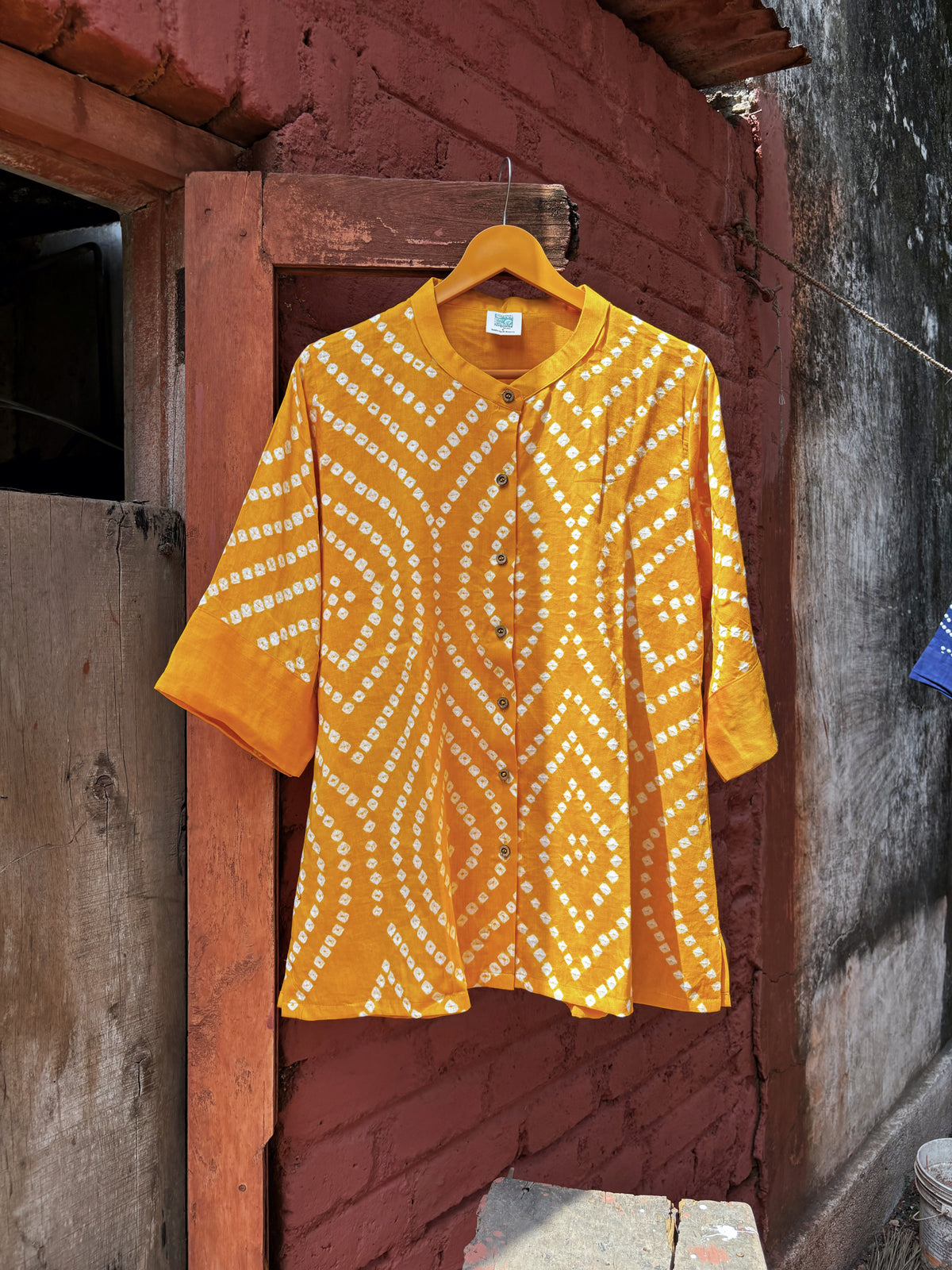Aamras mango-yellow cotton satin shirt with ivory hand tie-dyed Bandhani patterns, soft mandarin collar and button-down front.