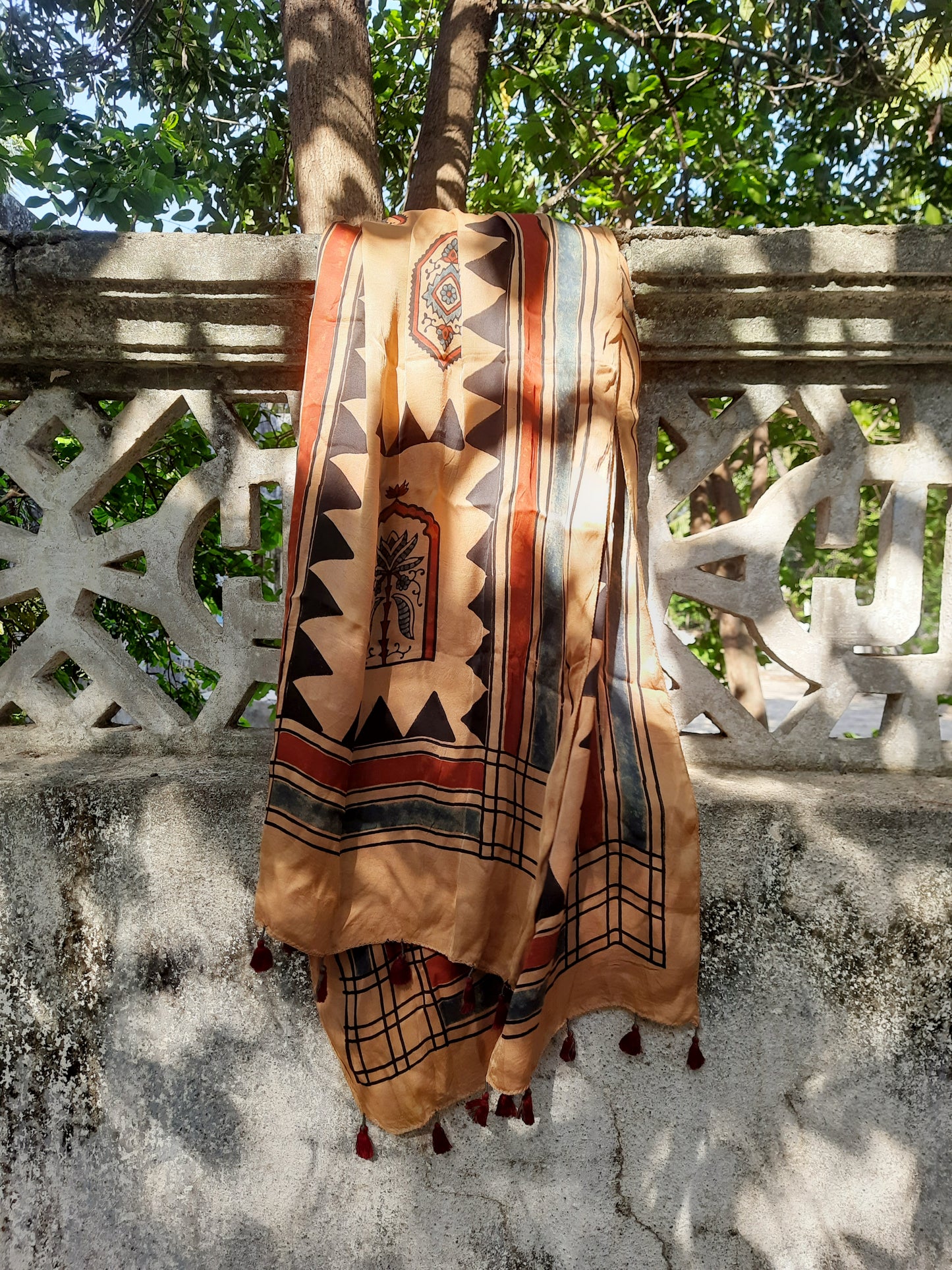 Earthy peach Ajrakh modal silk stole handcrafted with multiple hand block prints, naturally dyed with seasonal flowers, featuring a soft drape and tassels on both ends. Artisanal, sustainable, and one-of-a-kind.