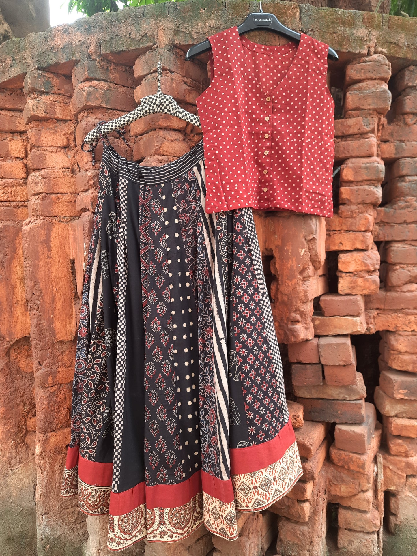 Handcrafted black Ajrakh hand block printed cotton skirt with multi prints and red polka dot sleeveless crop top, naturally dyed and slow-made by Turquoisethestore.