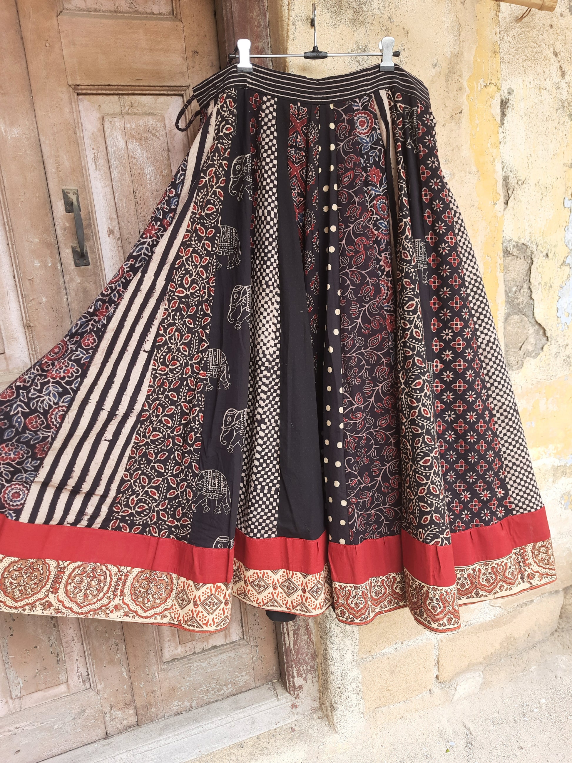 Handcrafted black Ajrakh hand block printed cotton skirt with multi prints and red polka dot sleeveless crop top, naturally dyed and slow-made by Turquoisethestore.