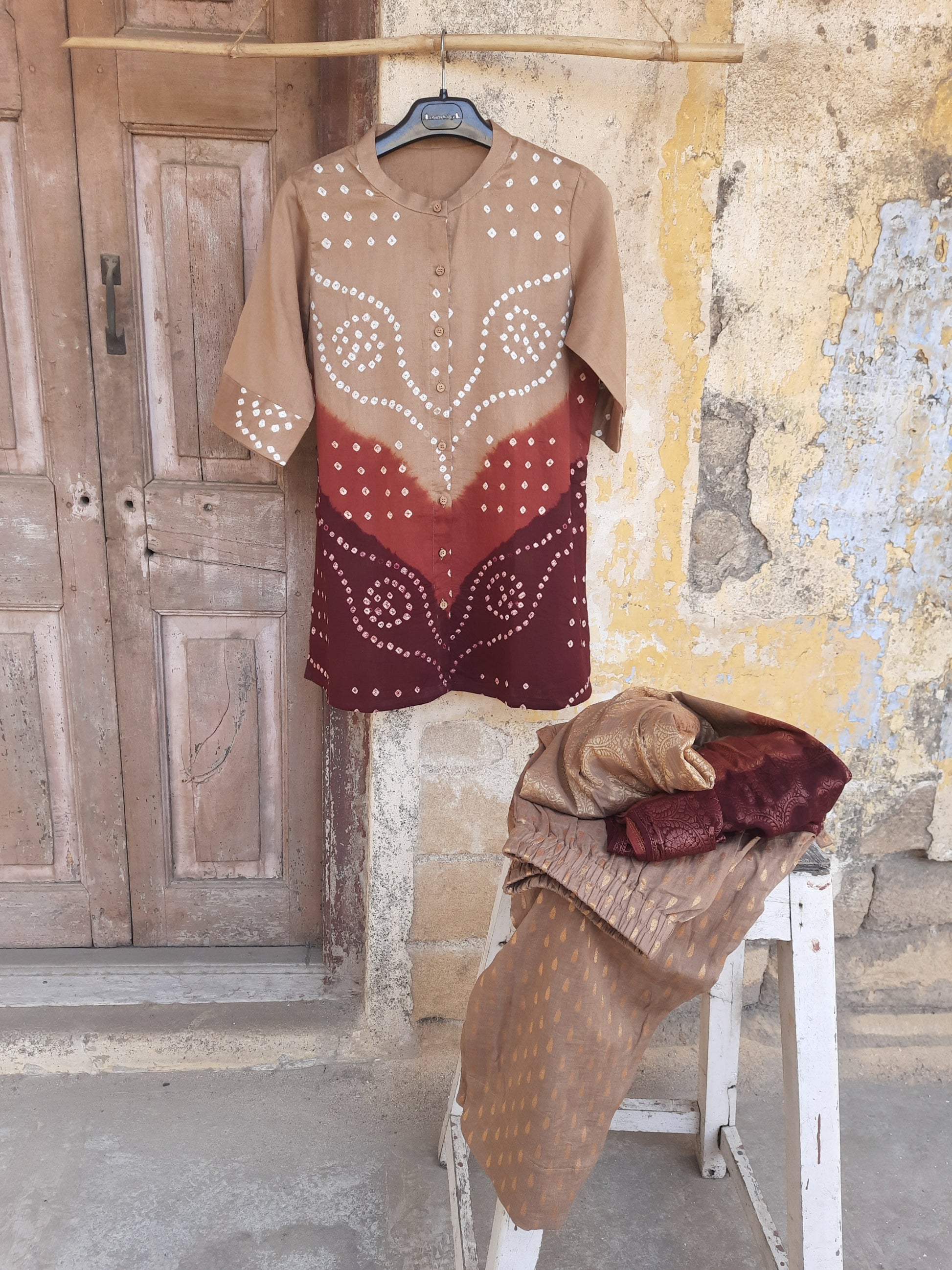 Hand tie dyed Bandhani cotton satin shirt in beige with rust and maroon detailing paired with jacquard pants and Banarasi weave dupatta