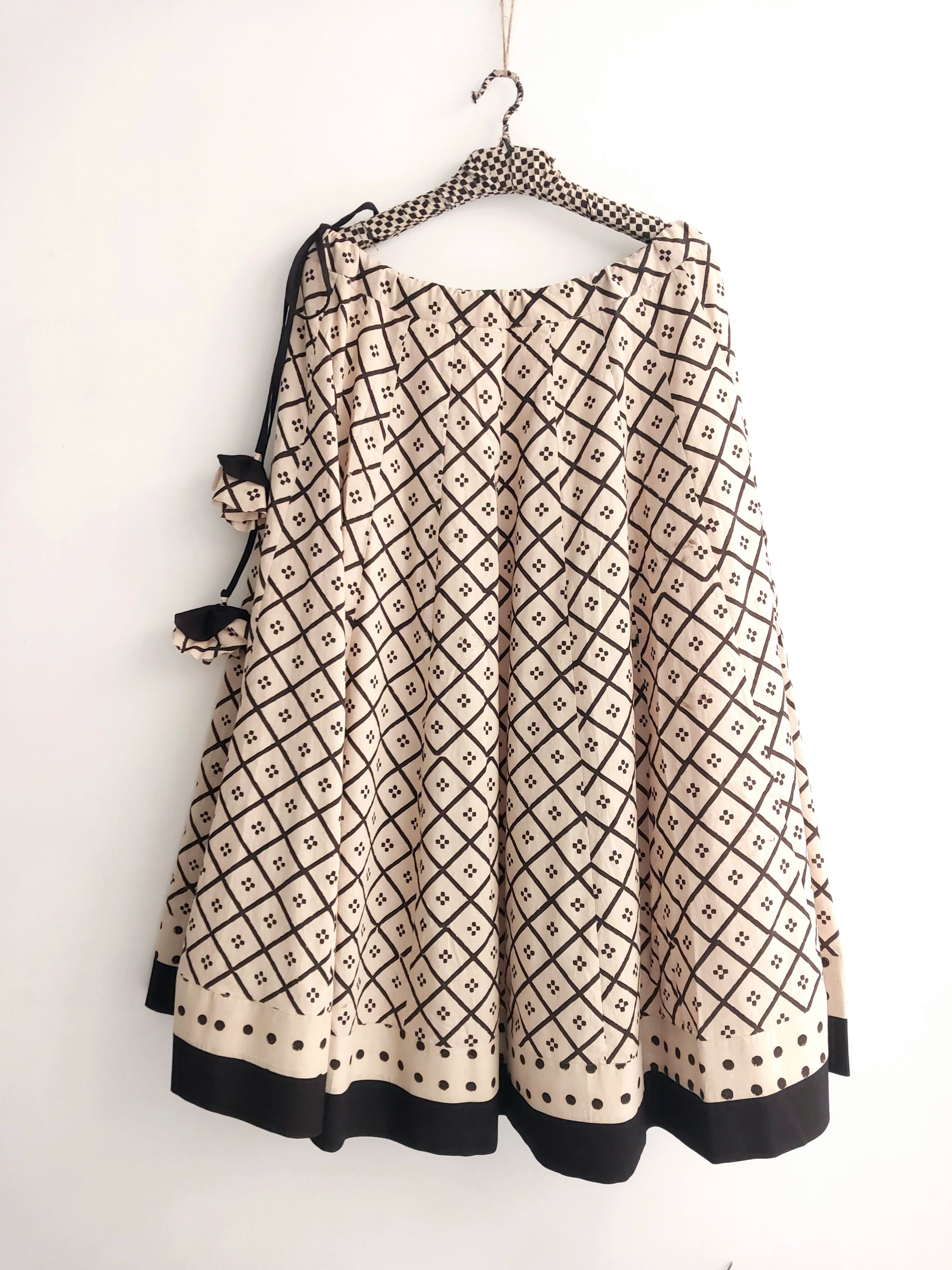 Beige natural dyed Ajrakh hand block printed kali-cut skirt with borders, side zip and drawstring. Handmade slow-made cotton skirt styled with a black Ajrakh blouse.