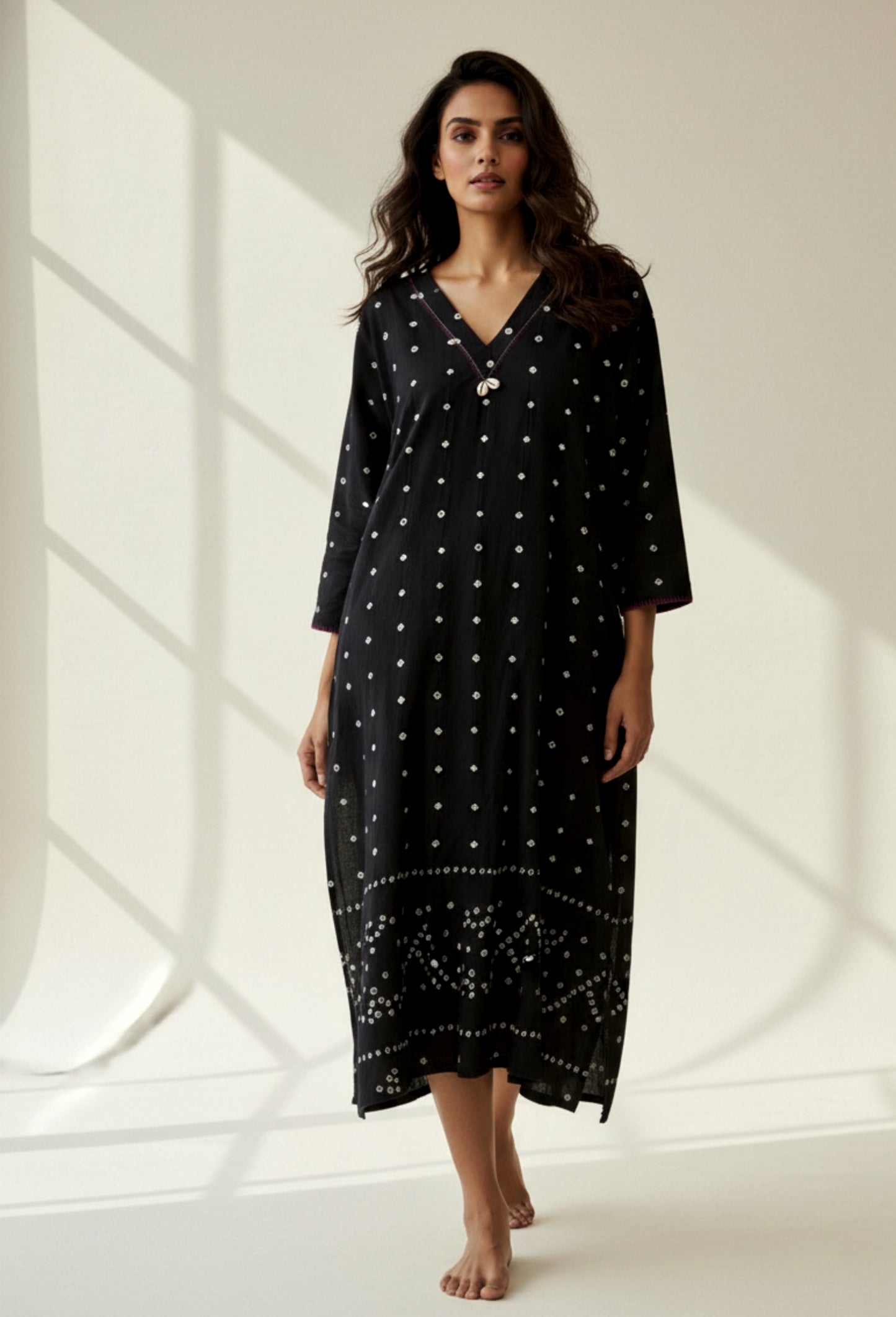 Handwoven organic cotton oversized Bandhani kurta for women with V-neck, cowrie detailing, full sleeves, and hand tie-dyed design handcrafted by artisans of Gujarat.