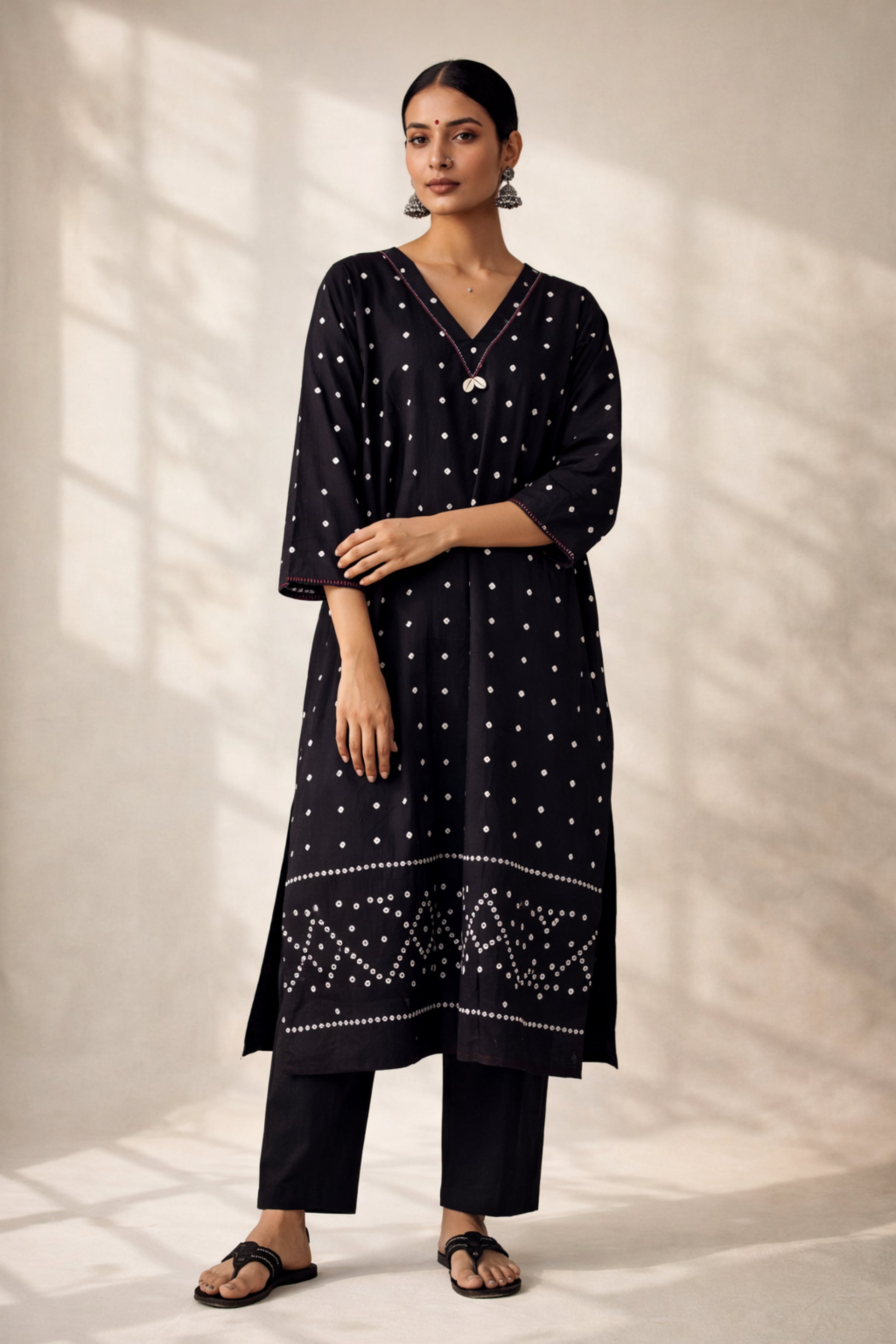 Handwoven organic cotton oversized Bandhani kurta for women with V-neck, cowrie detailing, full sleeves, and hand tie-dyed design handcrafted by artisans of Gujarat.