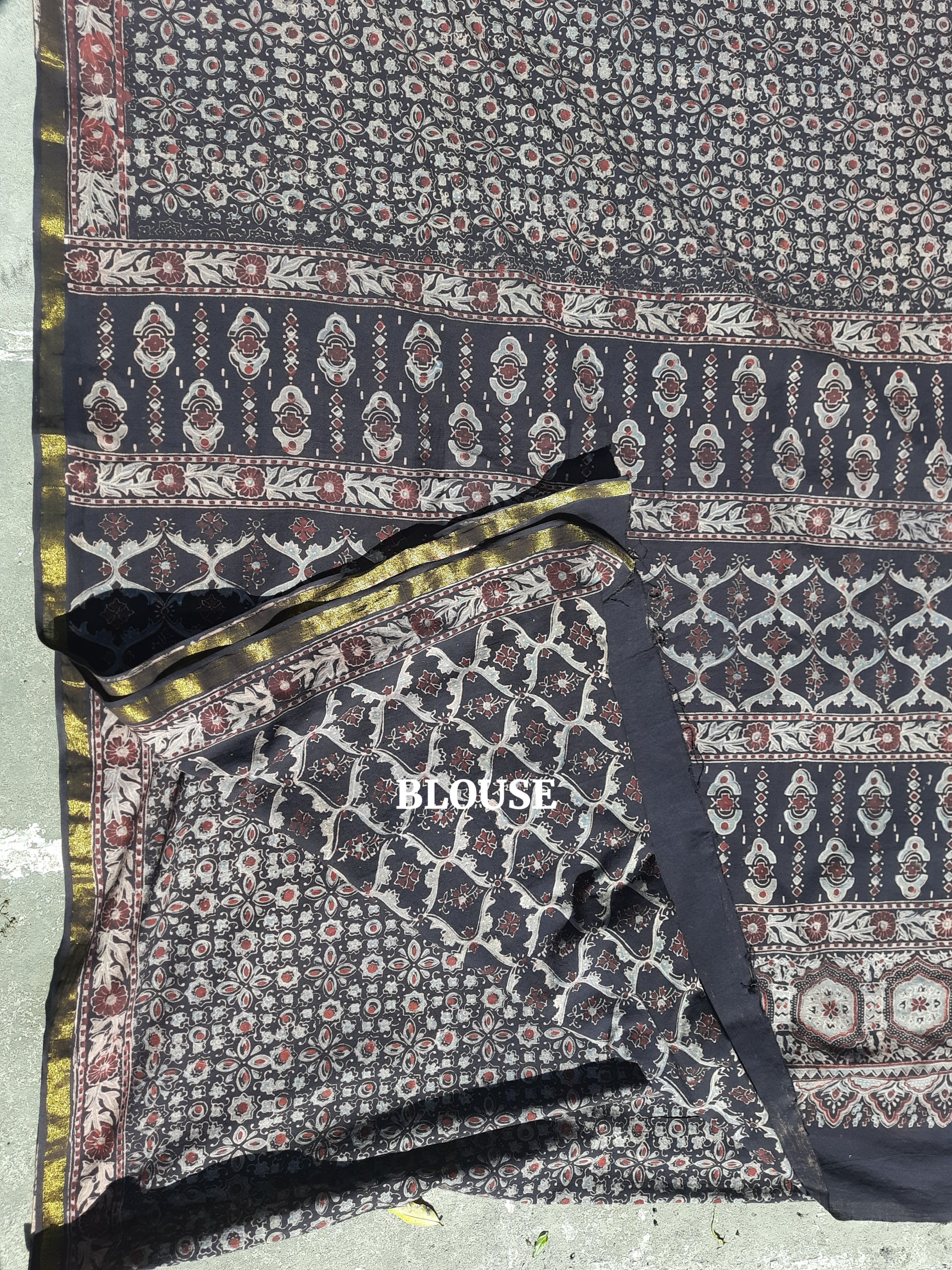 Black Ajrakh hand block printed pure cotton saree featuring traditional natural-dyed motifs and detailed Ajrakh border. Slow made, handmade saree measuring 6.30 meters with a 44-inch width.