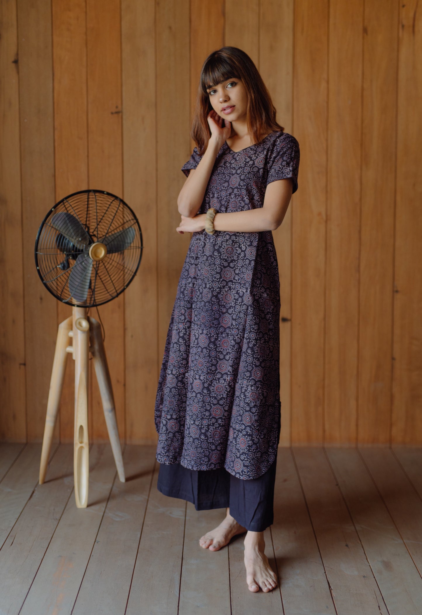 Black natural dyed Ajrakh hand block printed cotton kurta with curved V neck, short sleeves and U-hemline paired with plain black cotton palazzo pants featuring elasticated waist. Handmade, breathable, slow made Indian wear crafted in Gujarat.