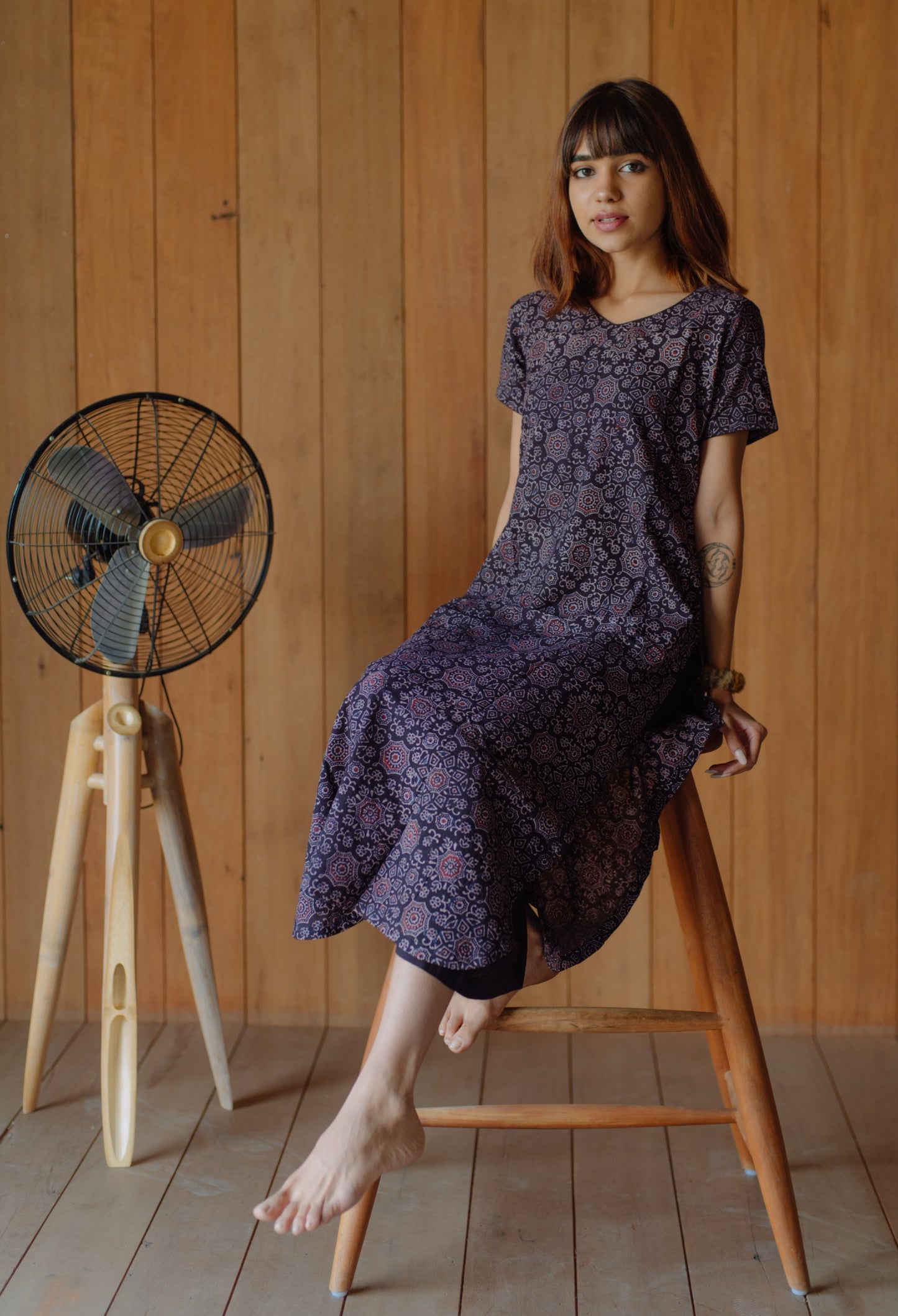 Black natural dyed Ajrakh hand block printed cotton kurta with curved V neck, short sleeves and U-hemline paired with plain black cotton palazzo pants featuring elasticated waist. Handmade, breathable, slow made Indian wear crafted in Gujarat.