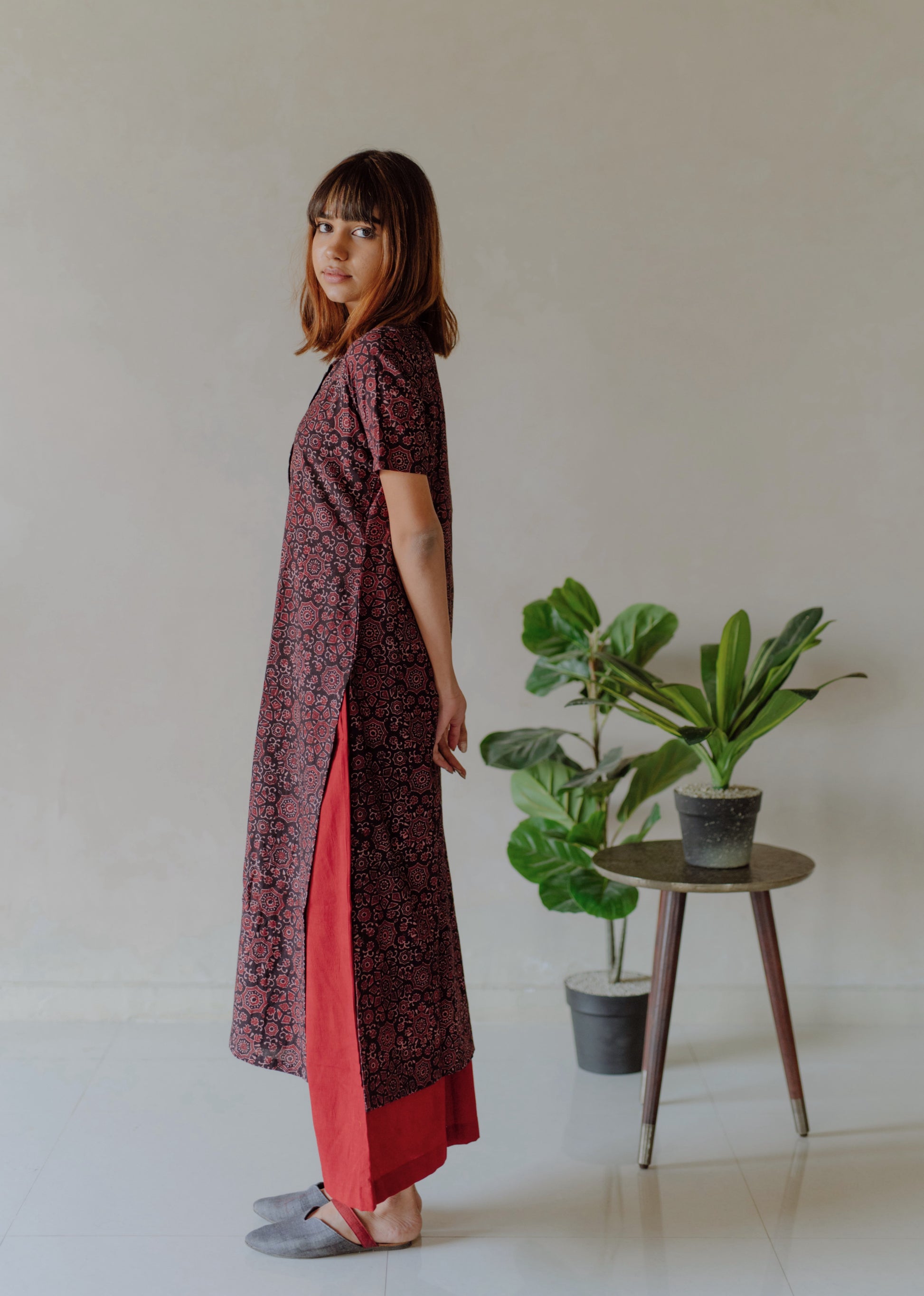 Natural black Ajrakh hand block printed cotton kurta with mandarin collar paired with madder red naturally dyed cotton pants featuring elasticated waist. Handmade, breathable, slow made Indian wear crafted by artisans in Gujarat.