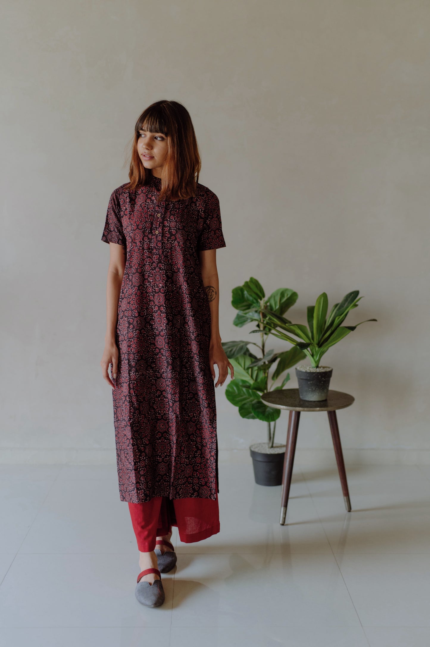 Natural black Ajrakh hand block printed cotton kurta with mandarin collar paired with madder red naturally dyed cotton pants featuring elasticated waist. Handmade, breathable, slow made Indian wear crafted by artisans in Gujarat.