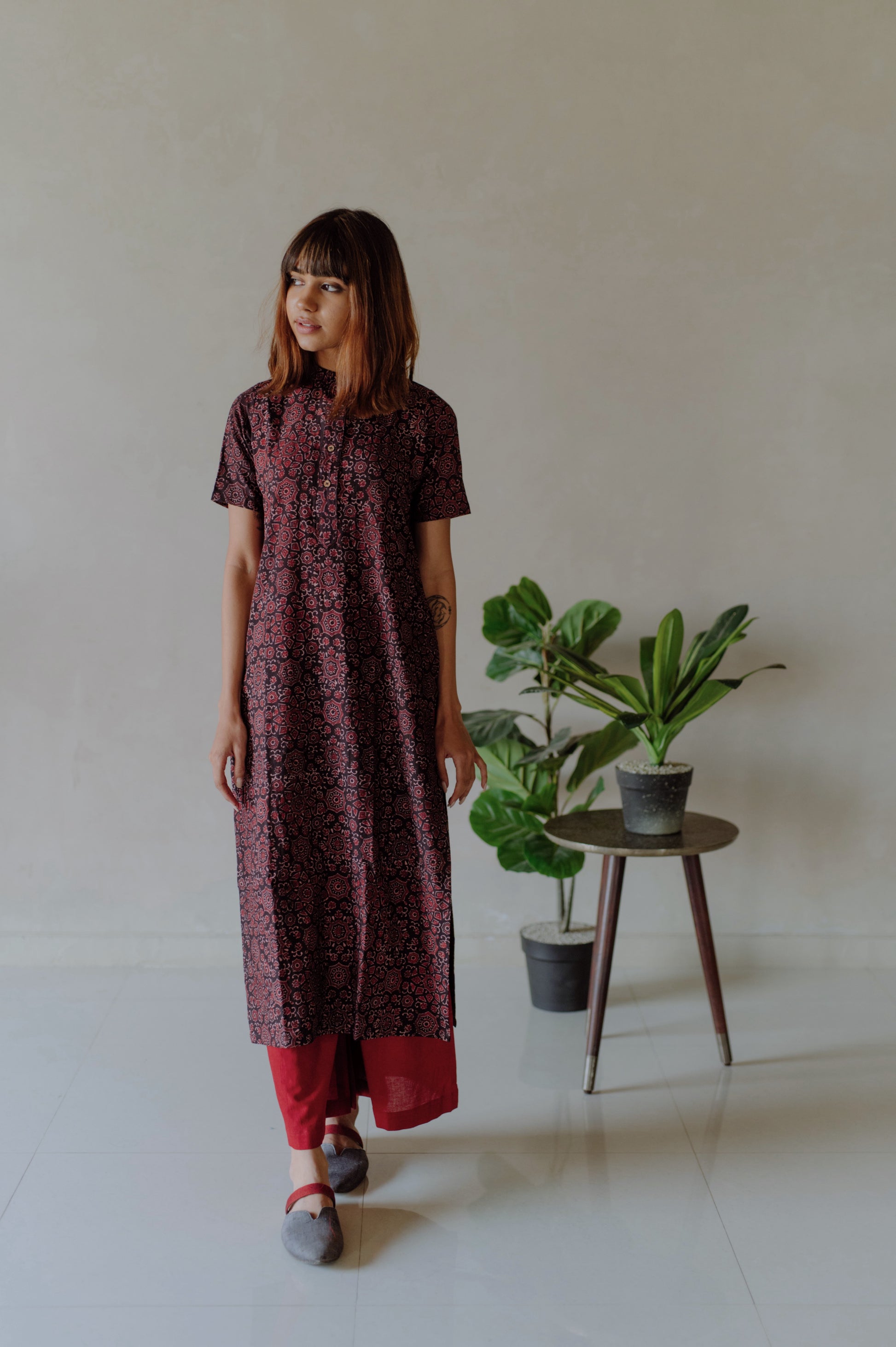 Natural black Ajrakh hand block printed cotton kurta with mandarin collar paired with madder red naturally dyed cotton pants featuring elasticated waist. Handmade, breathable, slow made Indian wear crafted by artisans in Gujarat.
