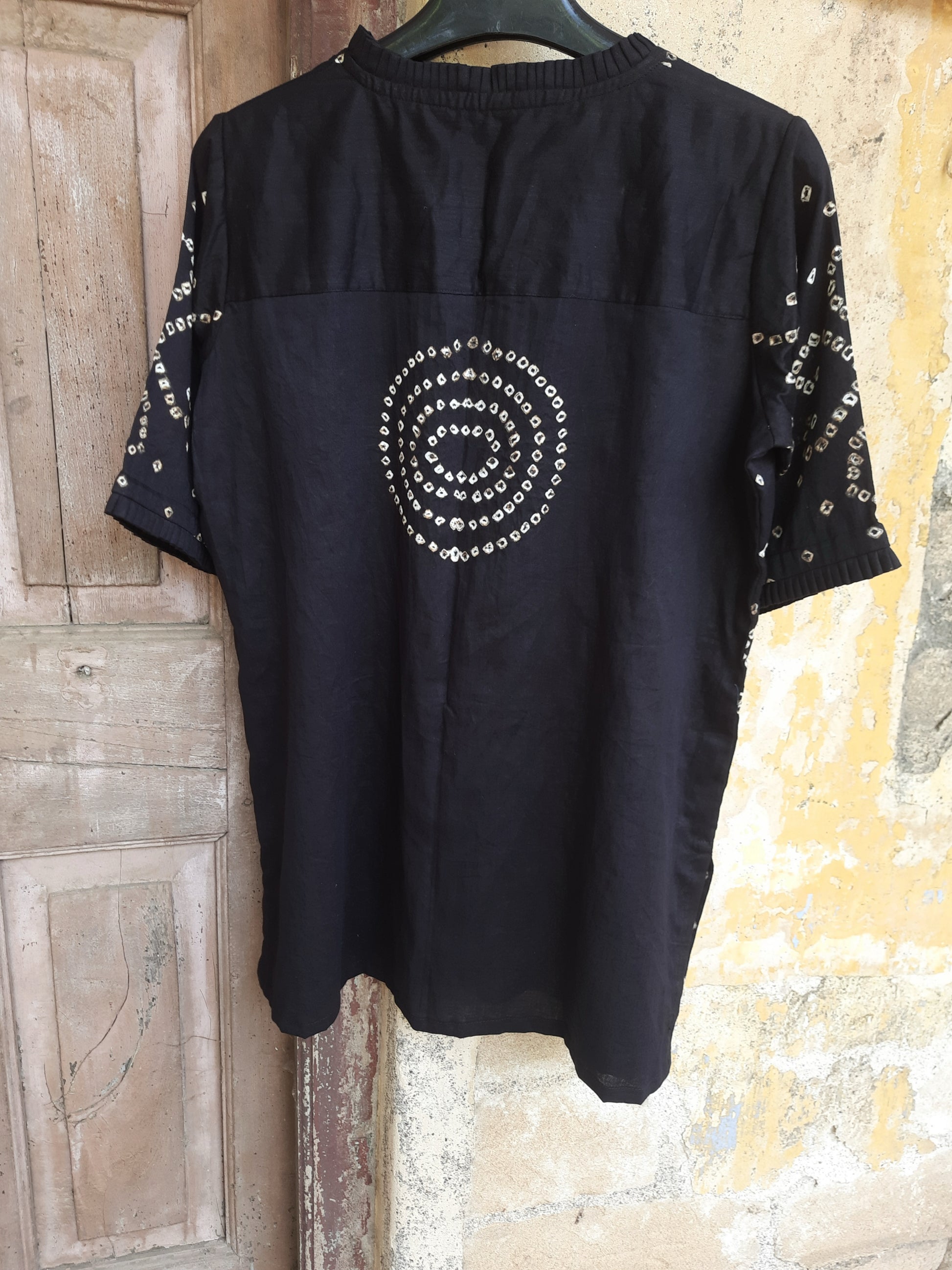 Handcrafted oversized black Bandhani shirt for women, made in cotton satin with pleated neck, elbow sleeves, short side slits, and traditional tie-dye detailing.