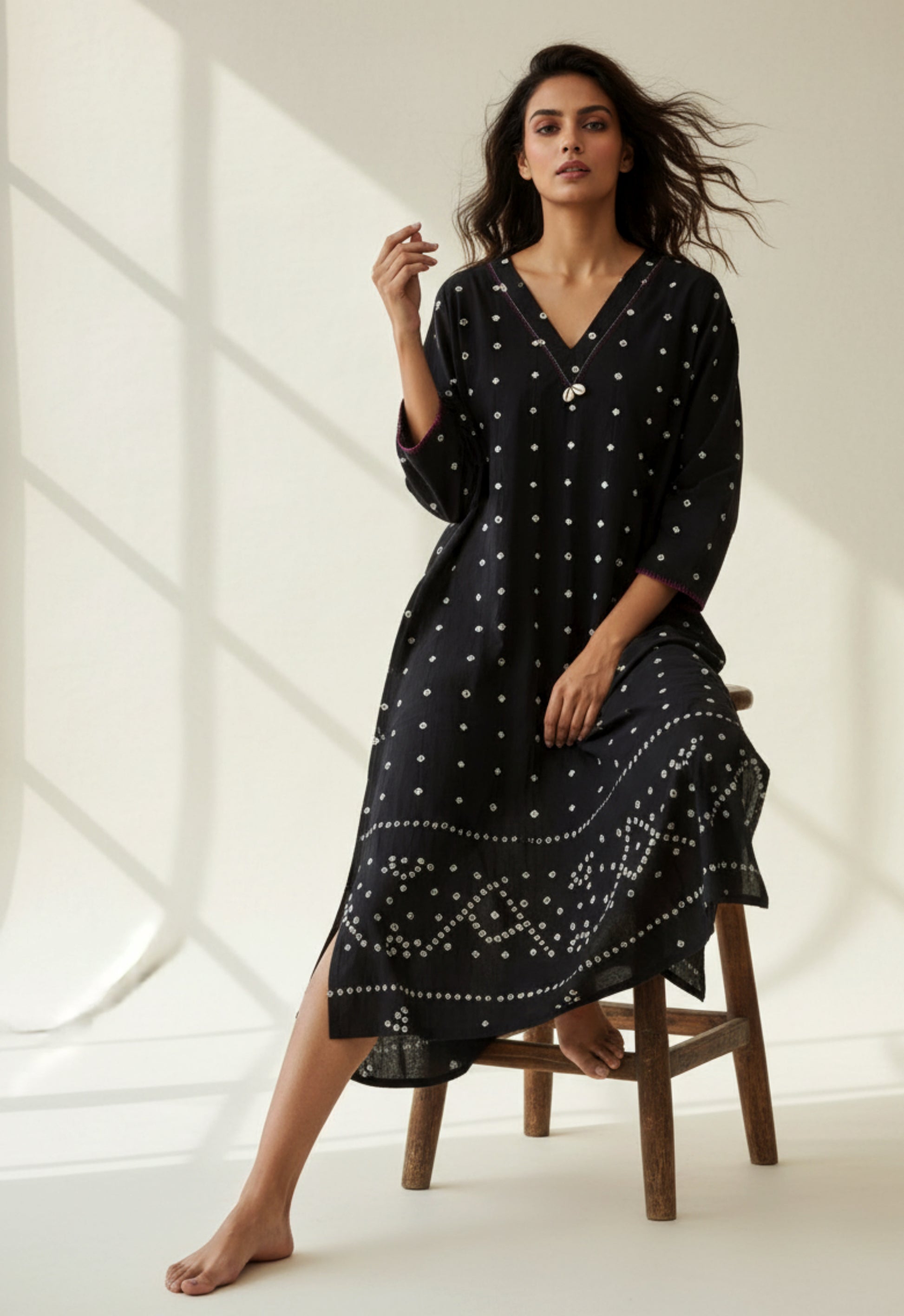 Handwoven organic cotton oversized Bandhani kurta for women with V-neck, cowrie detailing, full sleeves, and hand tie-dyed design handcrafted by artisans of Gujarat.