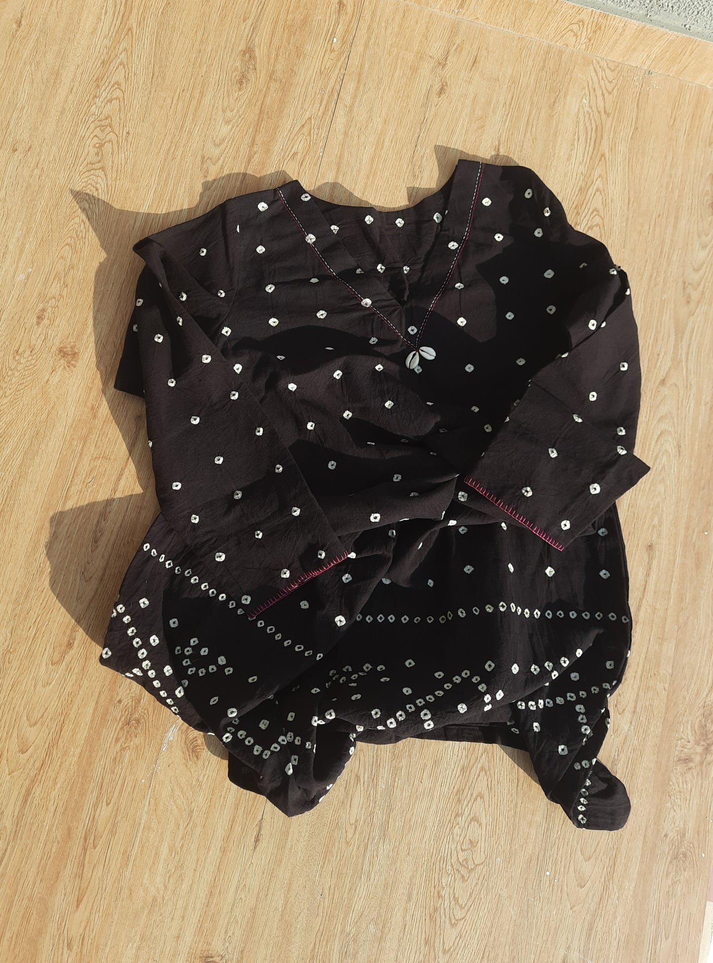 Handwoven organic cotton oversized Bandhani kurta for women with V-neck, cowrie detailing, full sleeves, and hand tie-dyed design handcrafted by artisans of Gujarat.