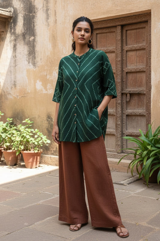 Green hand tie dyed Bandhani shirt crafted in hand spun and handwoven organic cotton, featuring a mandarin collared neck and long sleeves. Breathable, slow made, and handcrafted women’s shirt made using traditional Bandhani techniques in India.