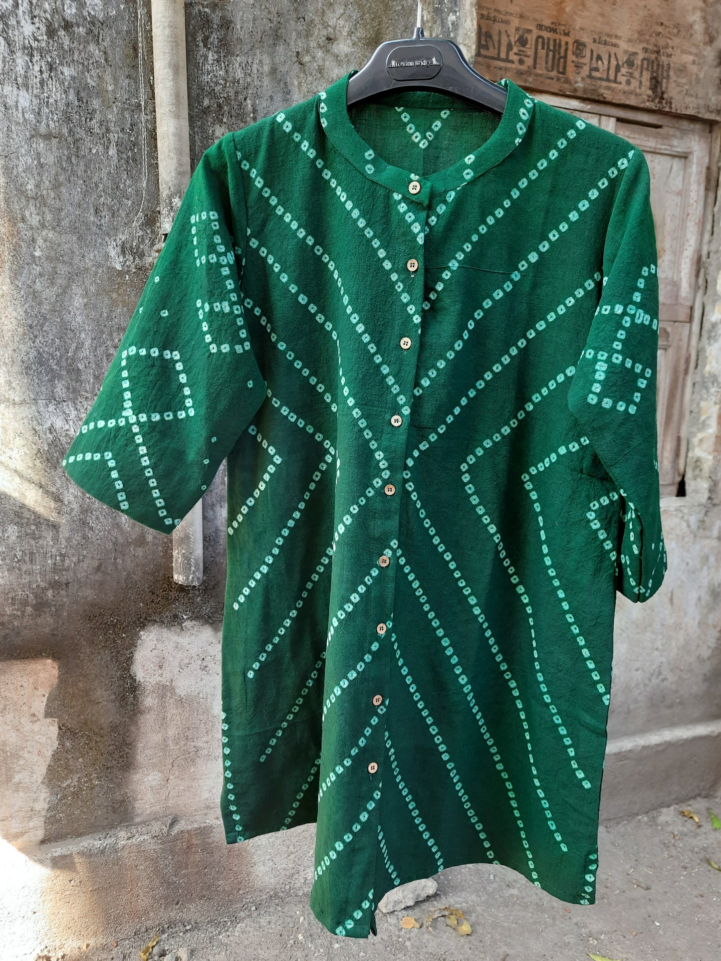 Green hand tie dyed Bandhani shirt crafted in hand spun and handwoven organic cotton, featuring a mandarin collared neck and long sleeves. Breathable, slow made, and handcrafted women’s shirt made using traditional Bandhani techniques in India.