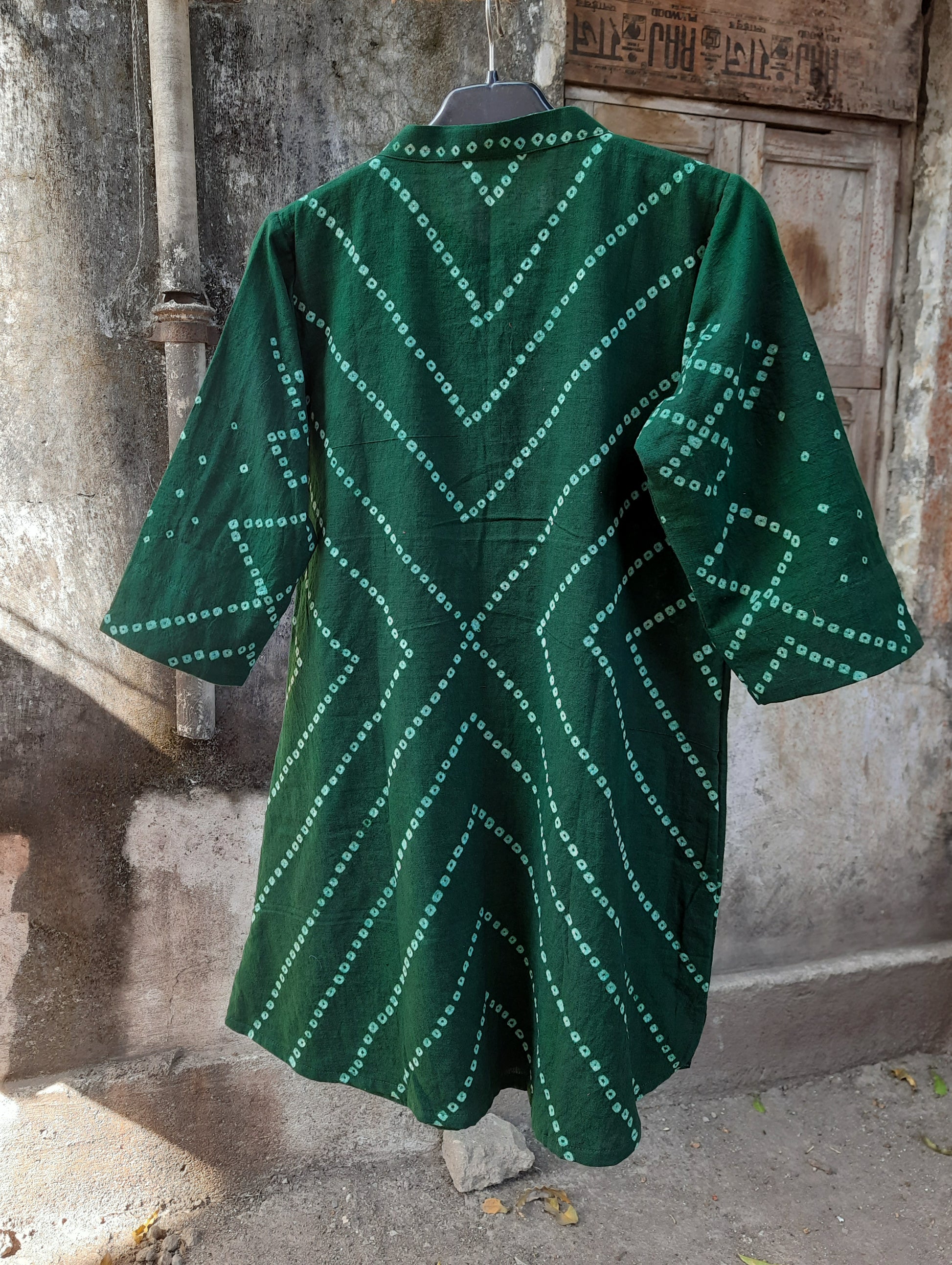 Green hand tie dyed Bandhani shirt crafted in hand spun and handwoven organic cotton, featuring a mandarin collared neck and long sleeves. Breathable, slow made, and handcrafted women’s shirt made using traditional Bandhani techniques in India.