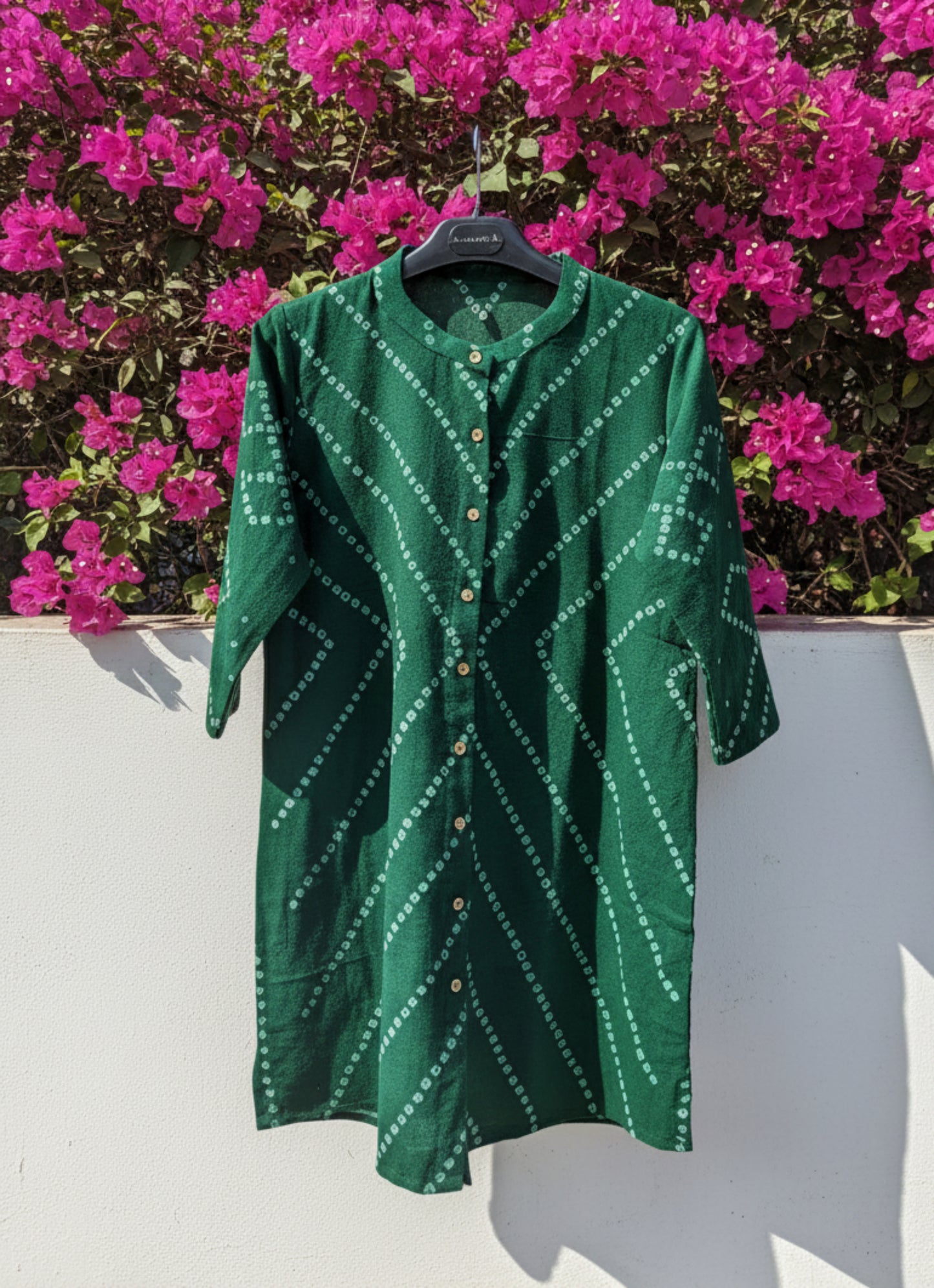 Green hand tie dyed Bandhani shirt crafted in hand spun and handwoven organic cotton, featuring a mandarin collared neck and long sleeves. Breathable, slow made, and handcrafted women’s shirt made using traditional Bandhani techniques in India.