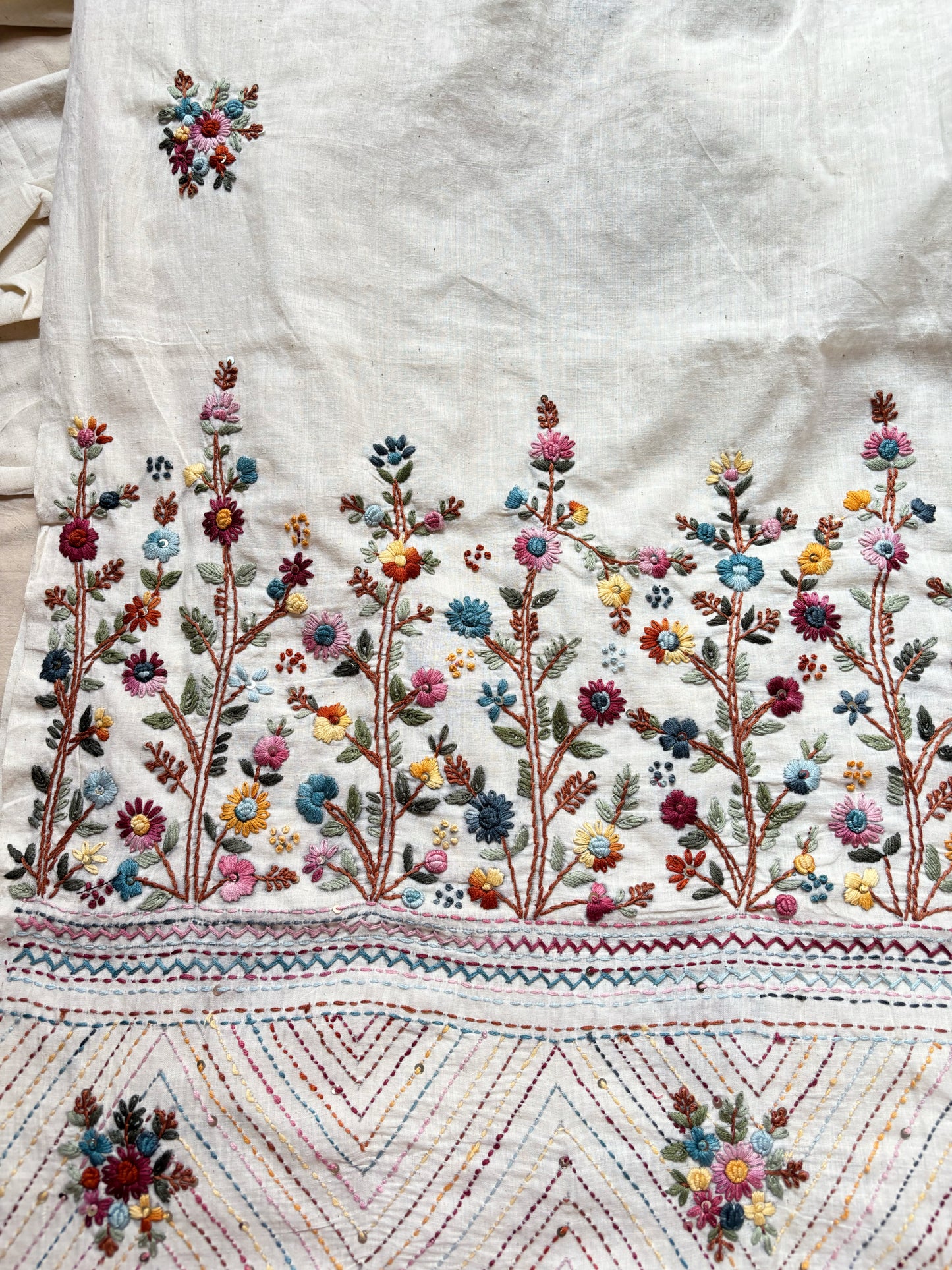 Handspun and handwoven cotton saree in natural ivory shade, featuring intricate hand embroidered floral motifs with subtle sequins. Slow made artisanal saree inspired by Basant, paired with a hand embroidered blouse piece.