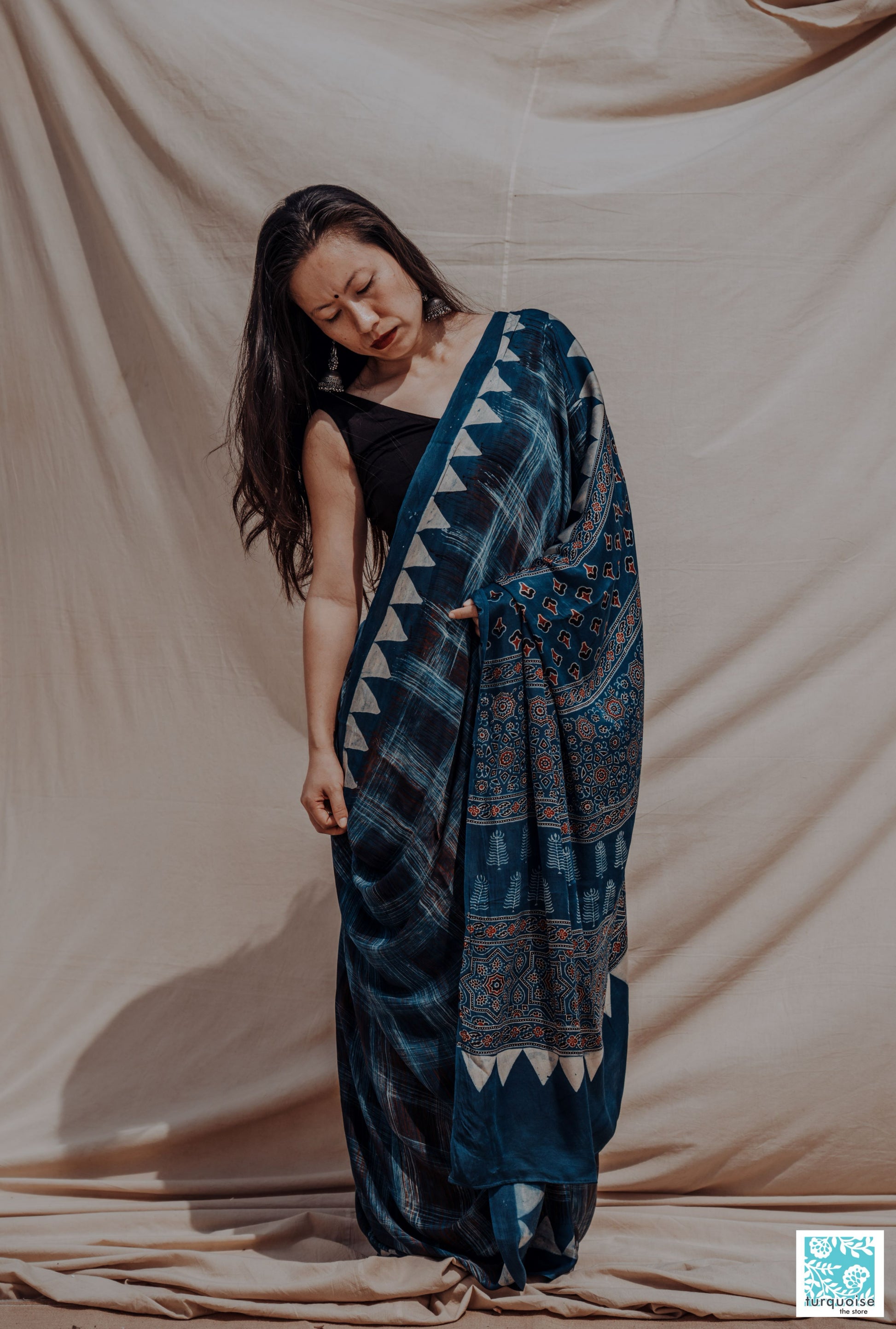 Indigo Ajrakh modal silk saree with natural dye, hand block printed brush-stroke patterns and traditional Ajrakh motifs. Slow-made, handcrafted saree in modal silk, 5.75 meters long, 44-inch width, includes blouse piece.