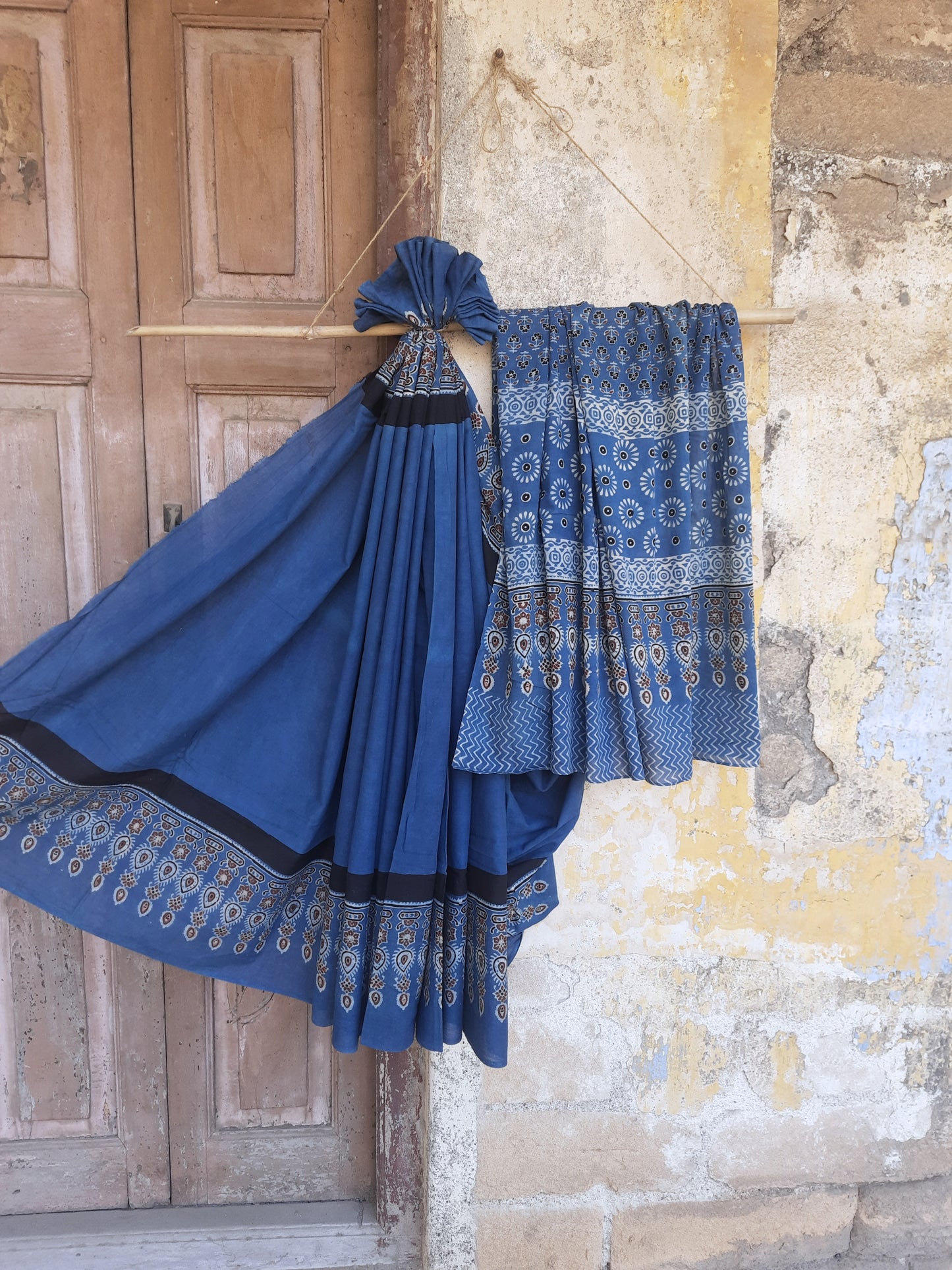 Solid indigo dyed Ajrakh hand block printed cotton saree featuring a calm indigo body with intricately printed Ajrakh borders and pallu. Natural dyed, breathable and slow made saree handcrafted by artisans in Gujarat.