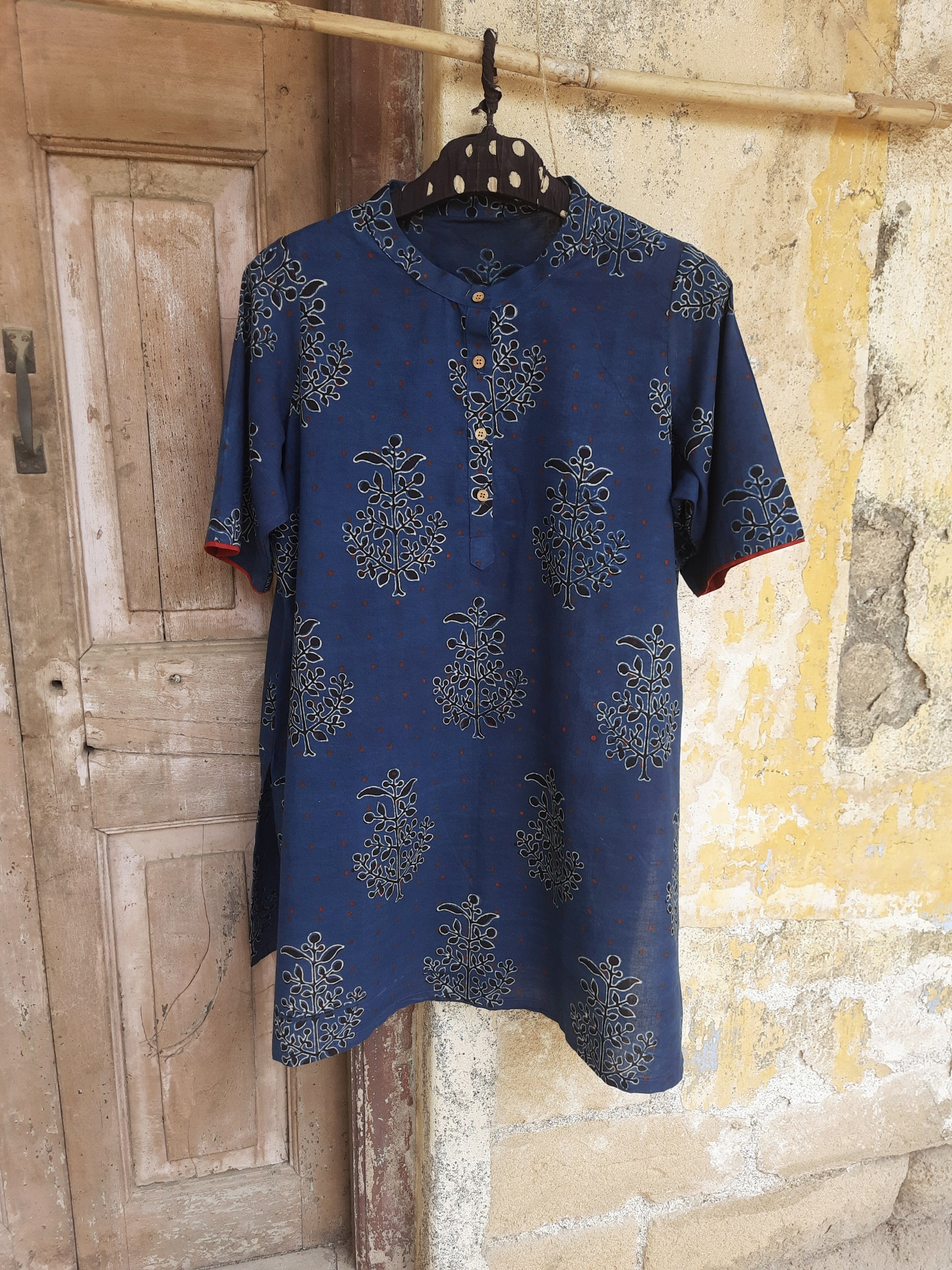 Indigo dyed Ajrakh hand block printed cotton short kurta for women featuring a mandarin collared neck, short sleeves and comfort fit, handcrafted using natural dyes for breathable everyday wear.