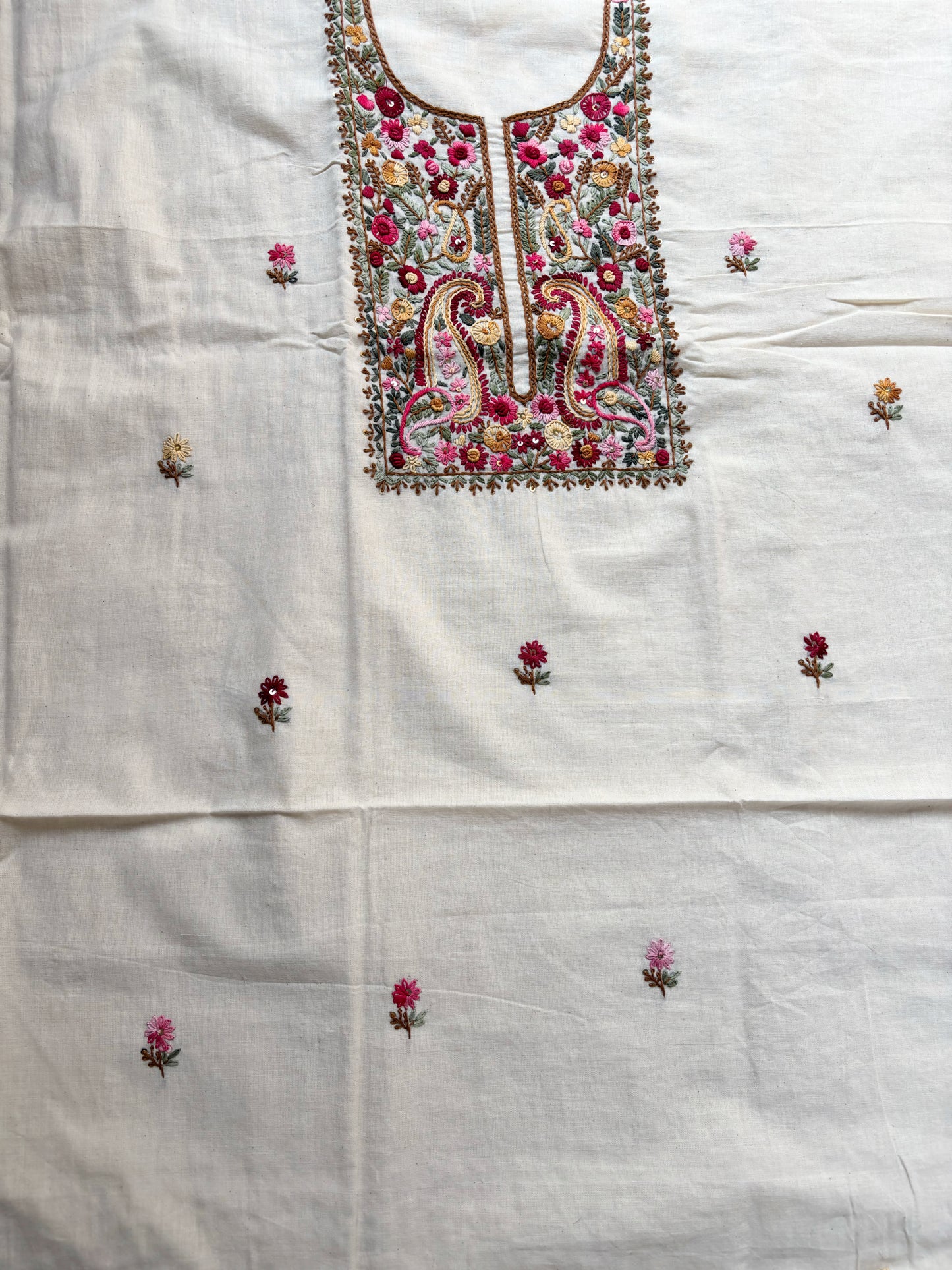 Handspun cotton unstitched kurta dupatta set featuring a richly hand embroidered paisley and floral yoke in warm pink, mustard, blue, and earthy tones, paired with a hand embroidered dupatta with floral vine borders and tassel edges.