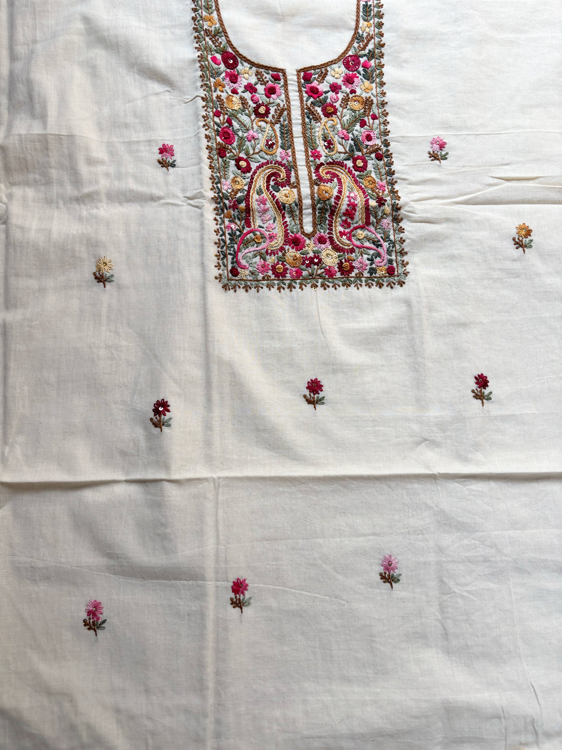 Handspun cotton unstitched kurta dupatta set featuring a richly hand embroidered paisley and floral yoke in warm pink, mustard, blue, and earthy tones, paired with a hand embroidered dupatta with floral vine borders and tassel edges.