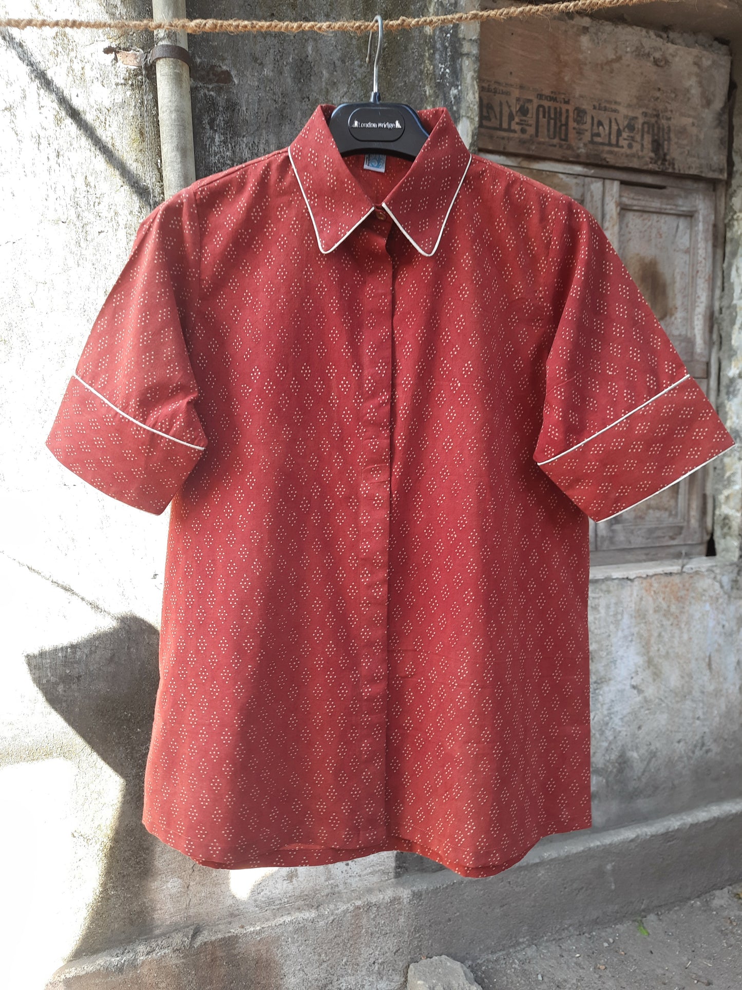 Madder dyed Ajrakh hand block printed cotton shirt for women in deep red tone, crafted in breathable pure cotton with a collared neck and contrast piping, naturally dyed and handmade for everyday comfort.