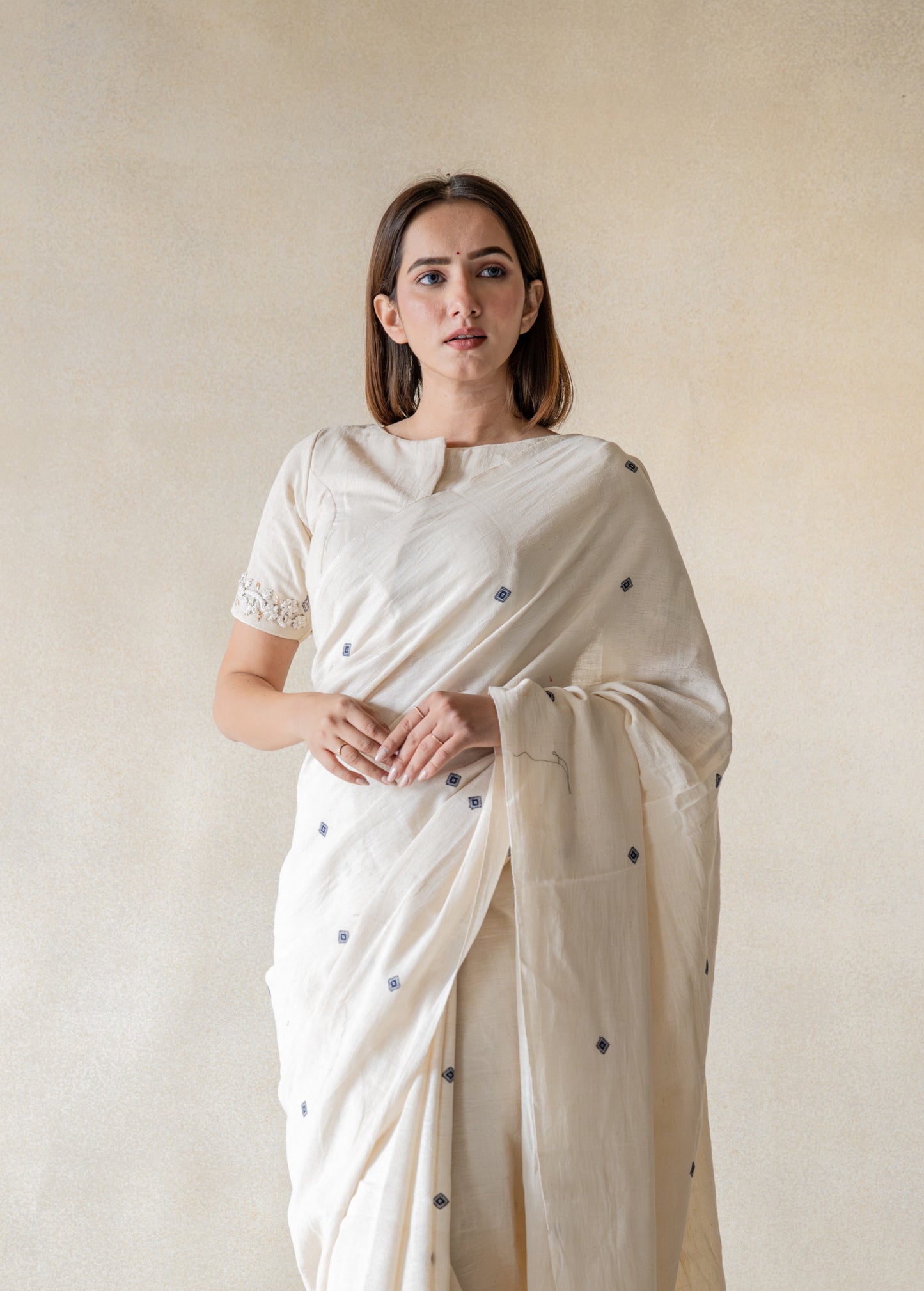 Off-white hand-embroidered organic cotton blouse, handspun and handwoven, featuring detailed embroidery on back and sleeves hem, closed round neck, 11-inch sleeves, handmade and slow-made artisan blouse.