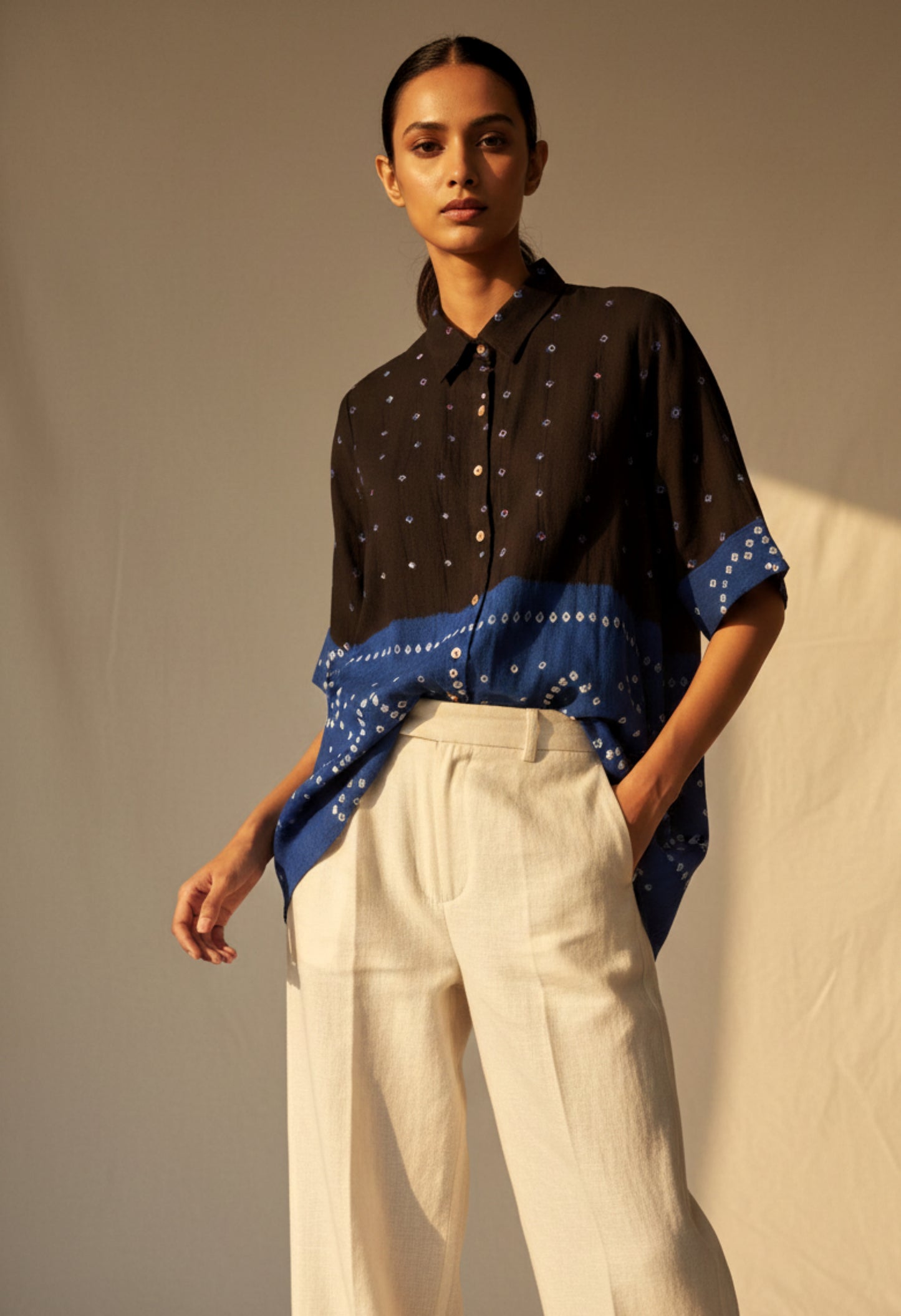 Black and indigo half-and-half Bandhani oversized shirt crafted in organic cotton, featuring hand tie dyed patterns and a relaxed silhouette. Breathable, slow made women’s shirt handcrafted using traditional Bandhani techniques in India.