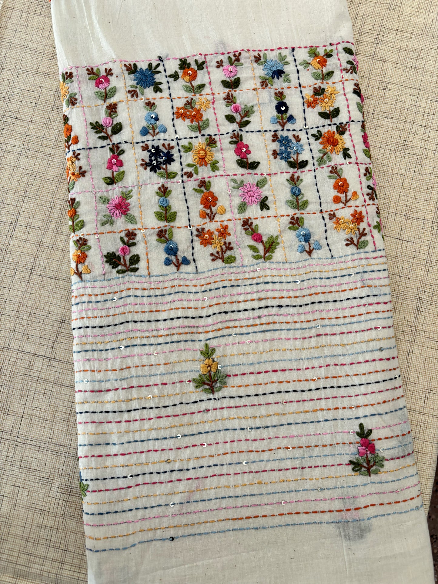 Handspun and handwoven cotton saree in warm ivory shade with expressive hand embroidered floral motifs and subtle sequin detailing. Slow made artisanal saree named Phagun, inspired by spring, with a hand embroidered blouse piece.