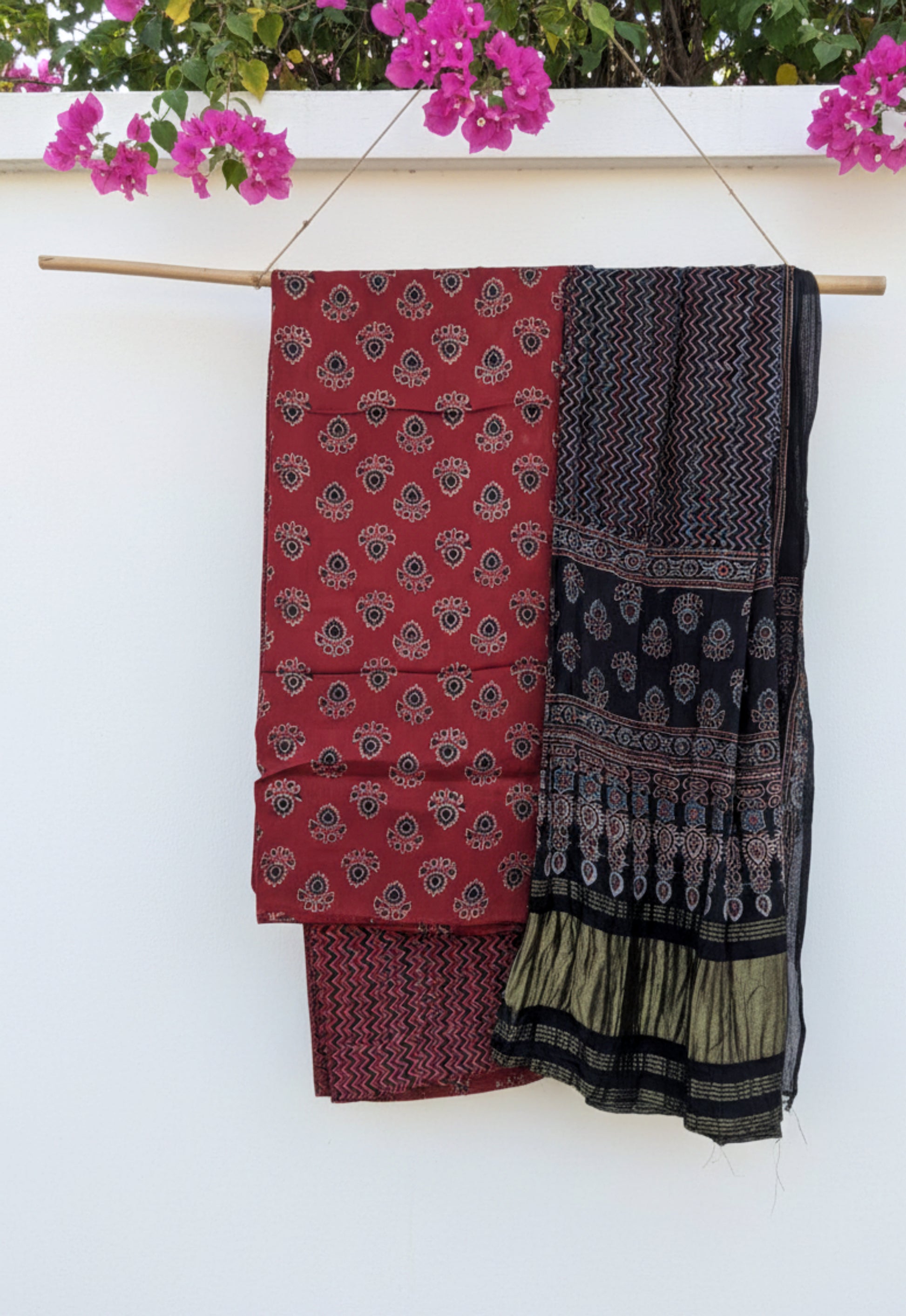 Ajrakh hand block printed unstitched suit set in red and black with traditional motifs and patterned dupatta.