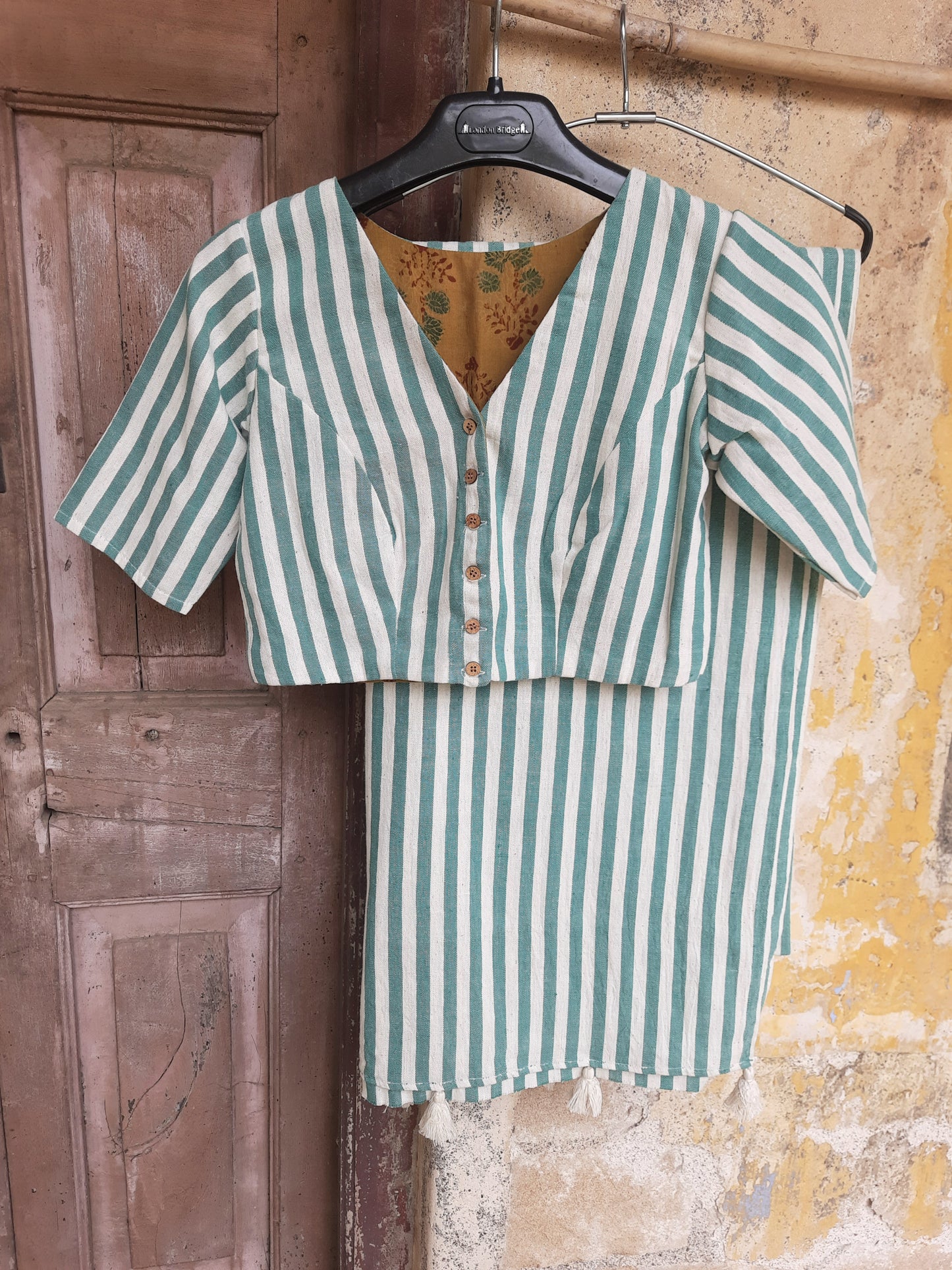Handcrafted green and off-white striped blouse in handspun and handwoven organic cotton, featuring a V-neck front, round closed neck behind, front button closure, and Ajrakh cotton lining. Slow made, breathable, and consciously crafted by Turquoisethestore.