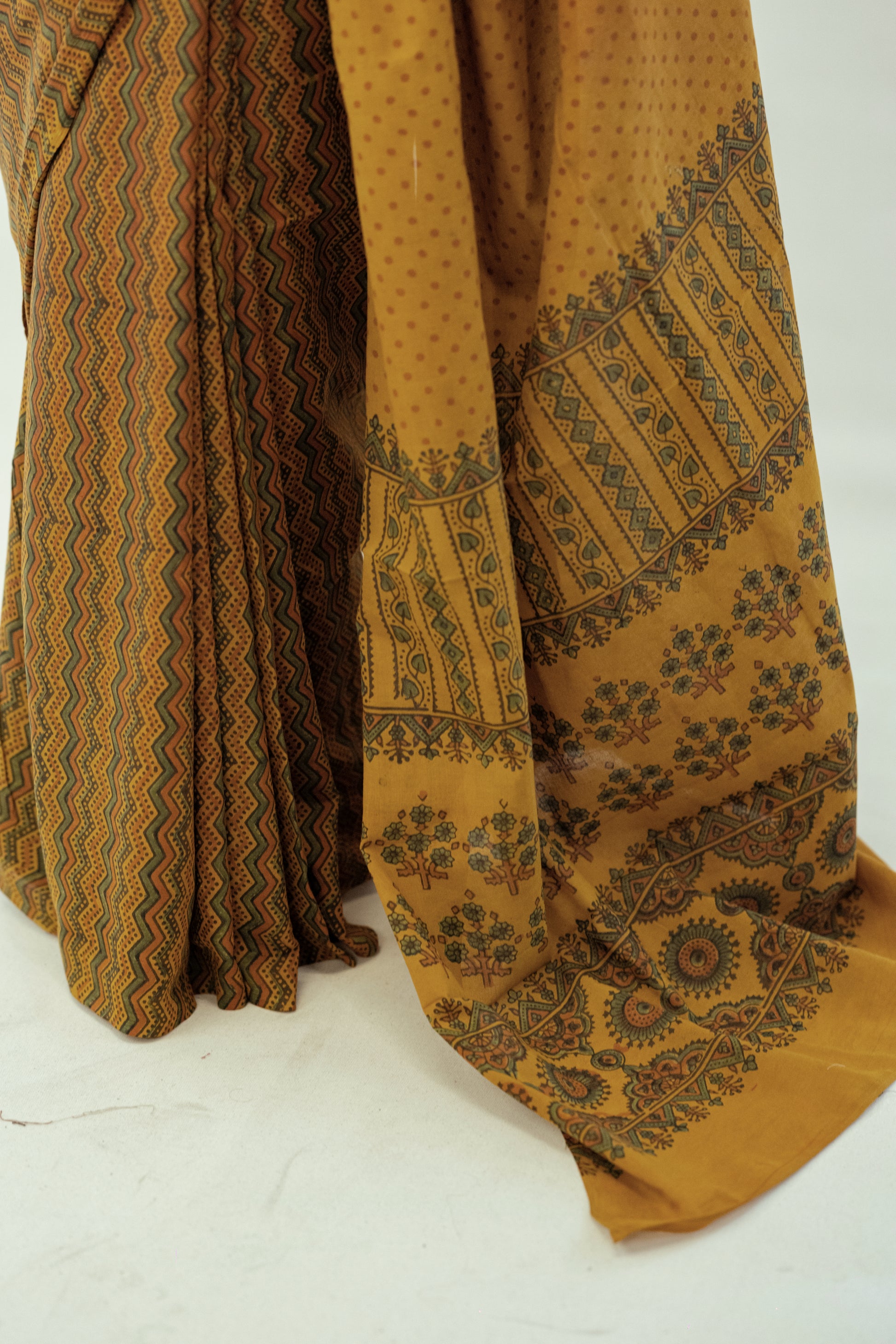 Turmeric dyed Ajrakh hand block printed cotton saree in muted mustard tone with geometric patterns