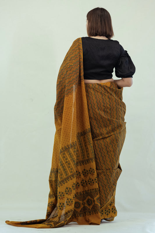 Turmeric dyed Ajrakh hand block printed cotton saree in muted mustard tone with geometric patterns
